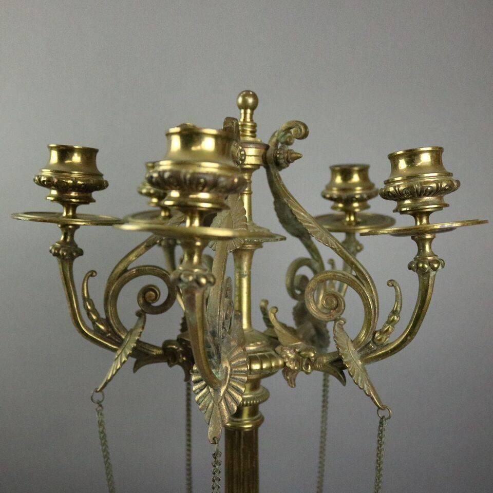 Pair of antique bronze five-light candelabra feature five lights with lion heads, scrolls and acanthus arms on reeded columns each atop three feathered falcon feet, circa 1890.

Measures: 26" H x 11" D