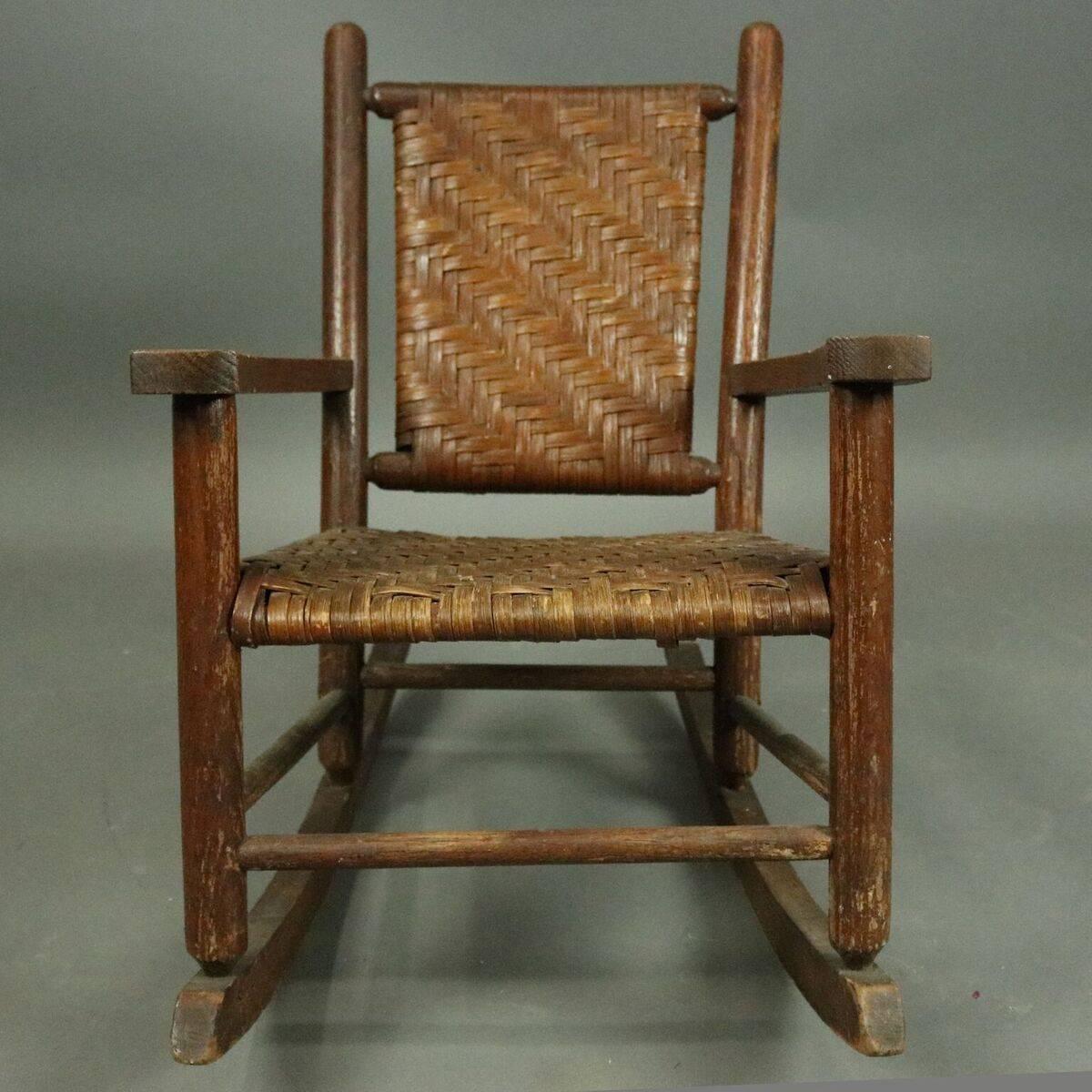 Antique old Adirondack style child's rocking chair features woven seat and back, circa 1920

Measures - 22.5" H x 16.5" W x 16" D, 12" seat height.