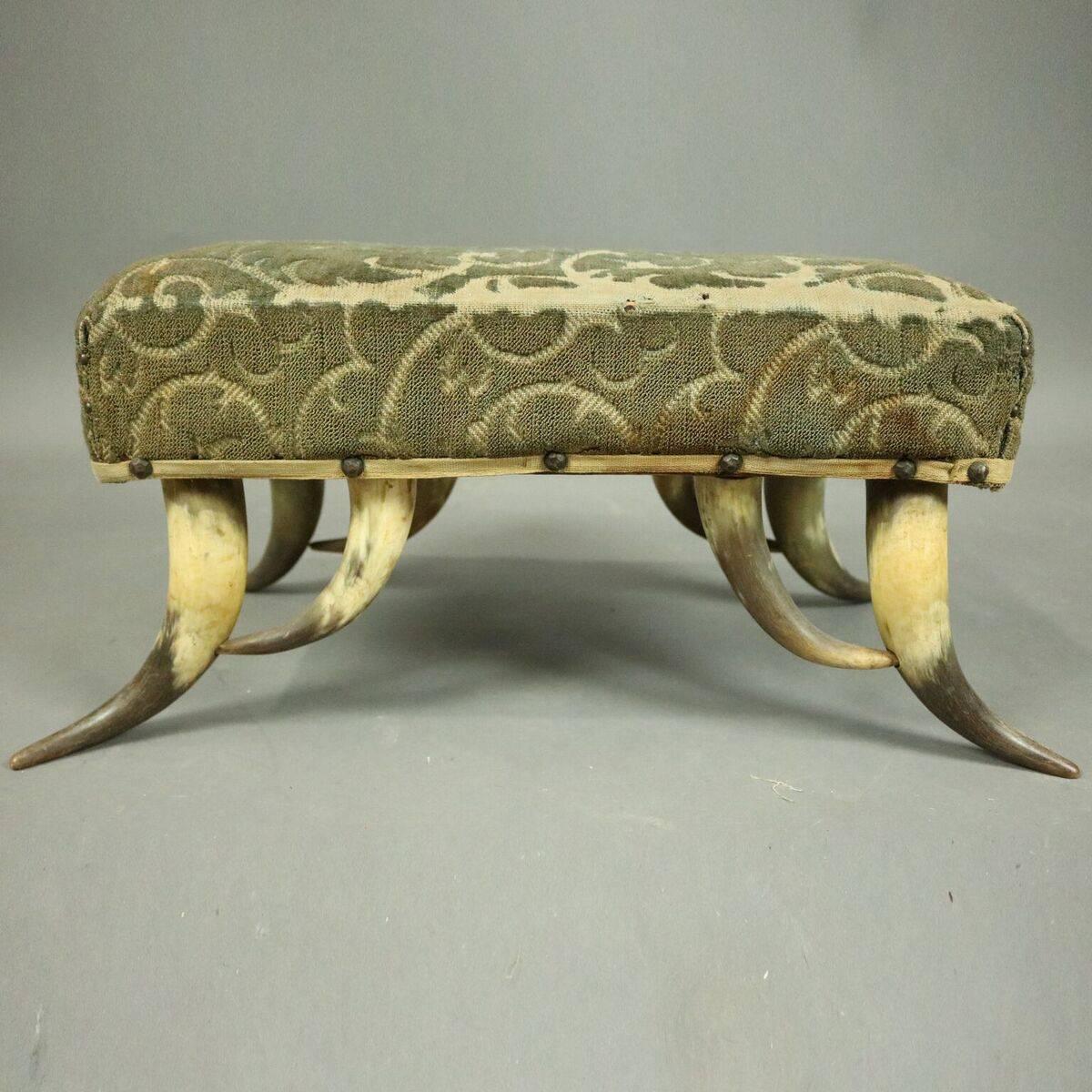 Antique Western footstool features cow Horn legs supporting upholstered upper,
circa 1910.

Measures: 9.5" H x 23" W x 12" D.