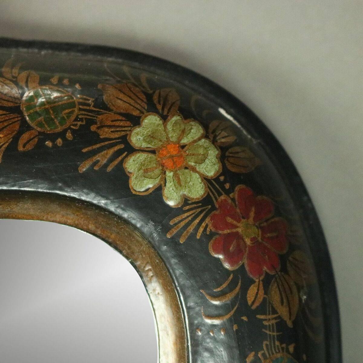 Vintage hand-painted wall mirror features chinoiserie decorated ebonized and gilt surround figures, butterflies, and foliage, circa 1930

Measures: 36.5