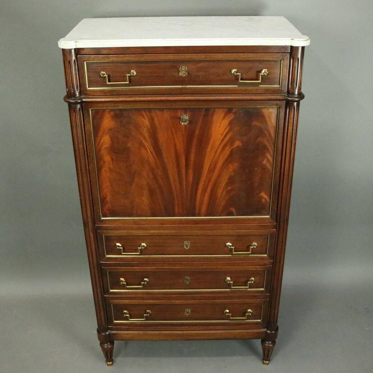 Antique Fench Louis XVI custom abattant features mahogany construction with marble top, flanking reeded columns, flame mahogany drop-front revealing gilt leather writing surface and interior storage, three long drawers below with one above, bronze