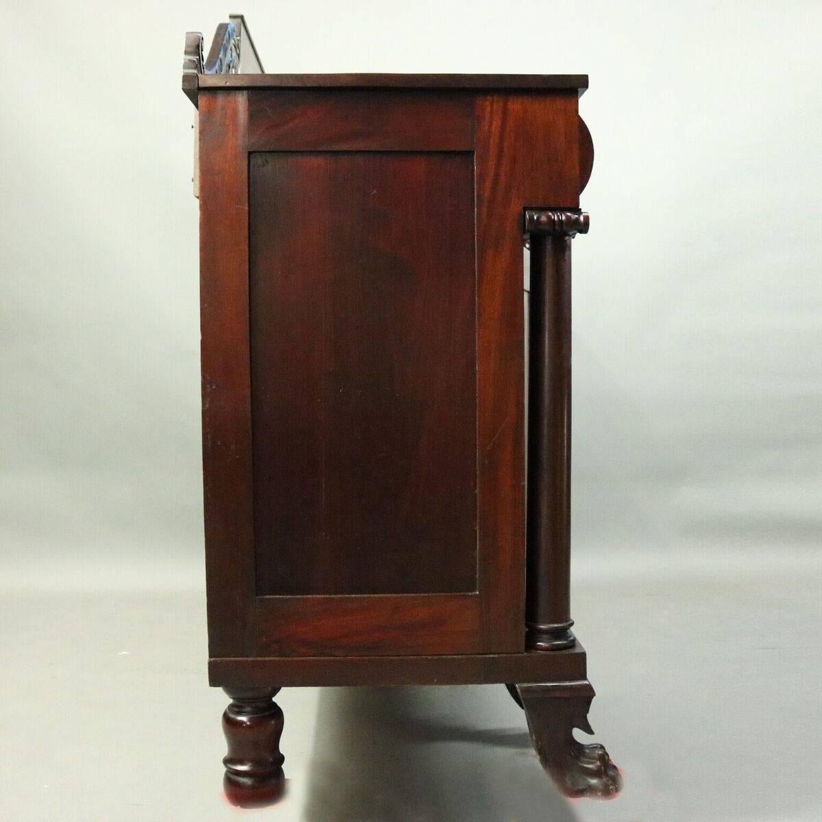 Antique American Empire Philadelphia Quervelle School sideboard features mahogany construction with acanthus carved backsplash, full columns with volute caps and stepped bases, carved acanthus and paw feet, convex upper drawers, circa