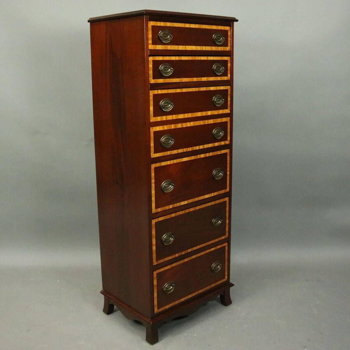 Vintage English lingerie chest features mahogany construction with seven banded drawers (four shallow and three deep drawers) with satinwood inlay, bronze pulls, circa 1940.

Measures: 52.25