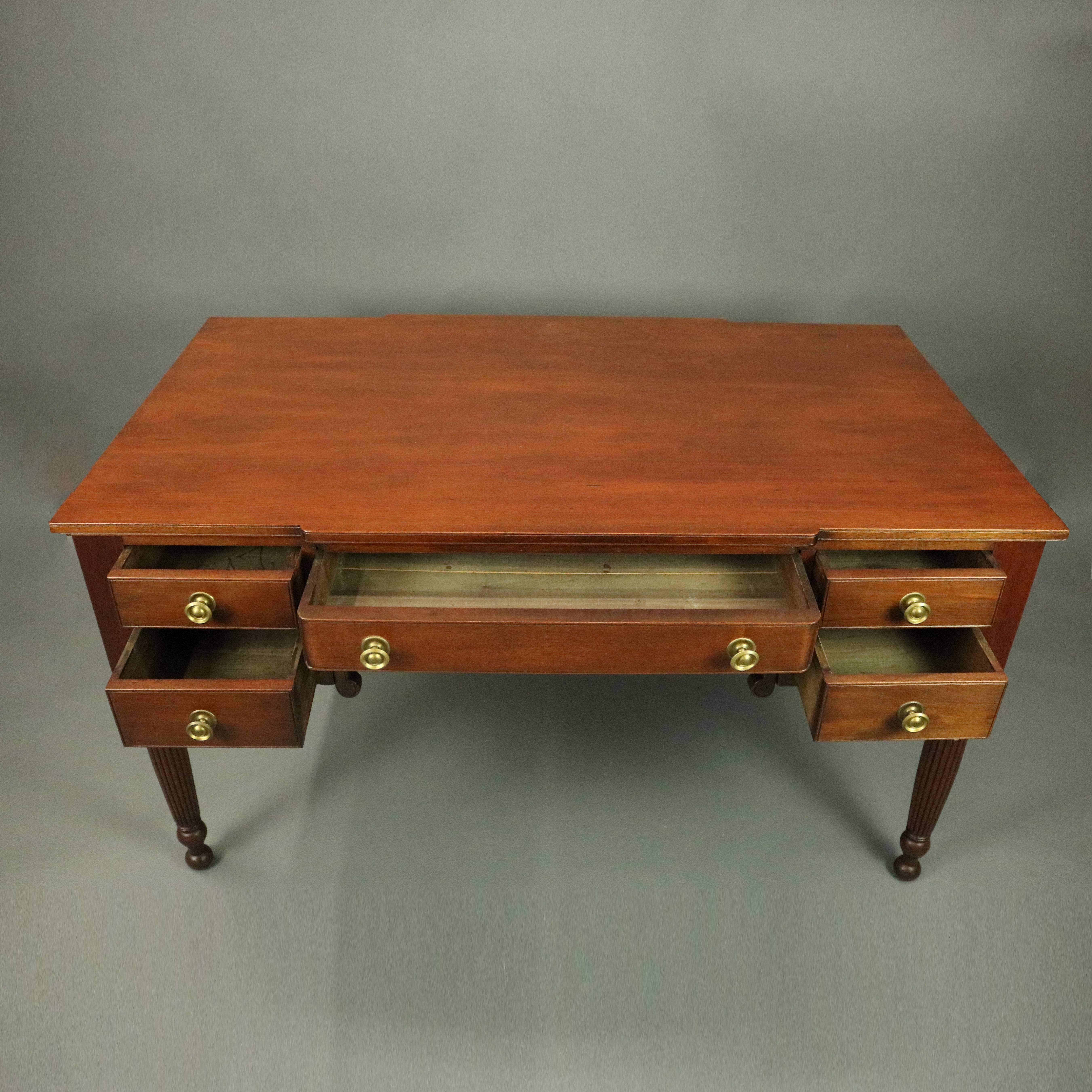 Antique English Sheraton mahogany partners desk features turned and reeded legs below case, each side with one central drawer flanked by two side drawers, bronze hardware throughout, circa 1820

Measures: 30.5" H x 55.5" W x 32.25"