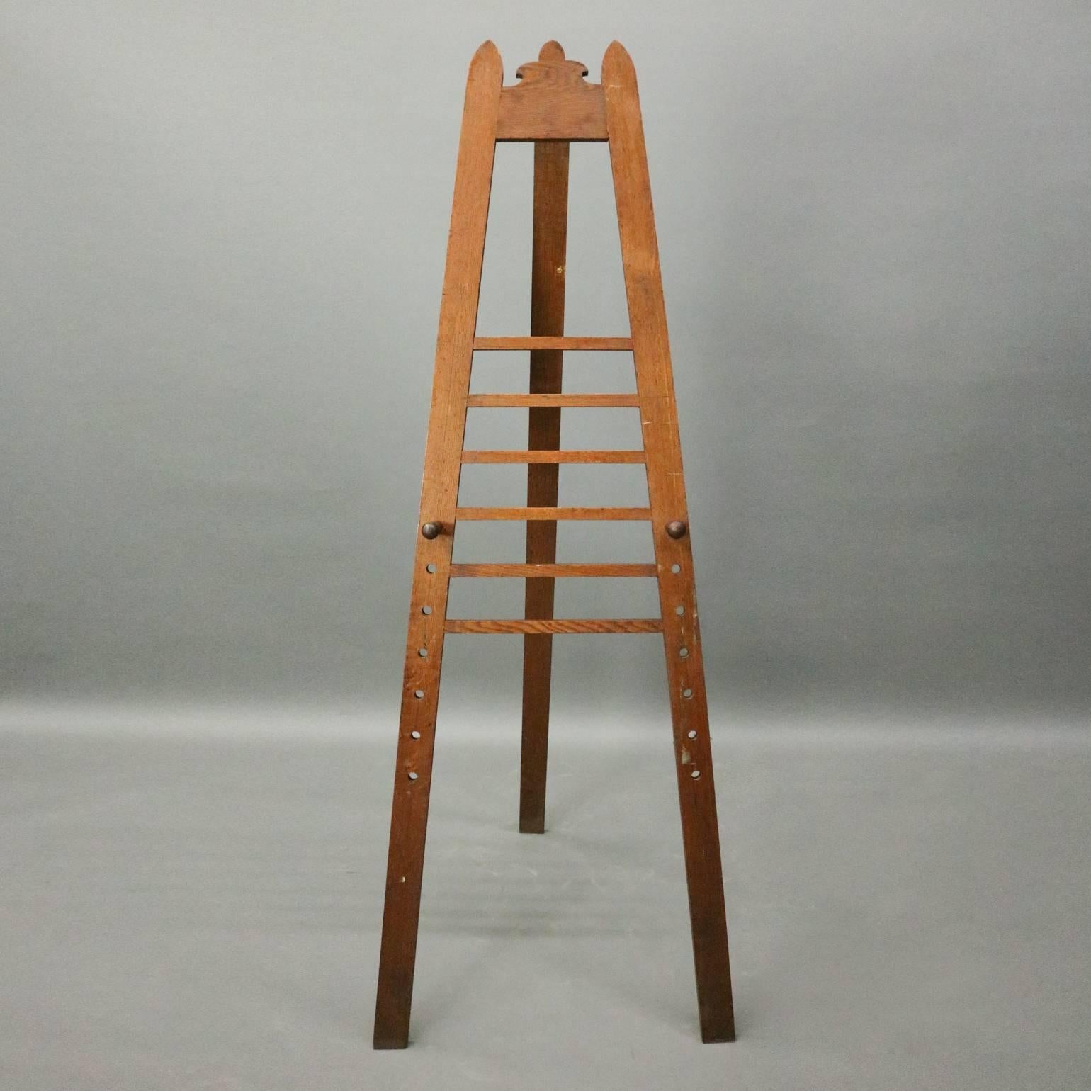 Antique walnut art easel features walnut construction with slat back display and adjustable pegs, circa 1900.