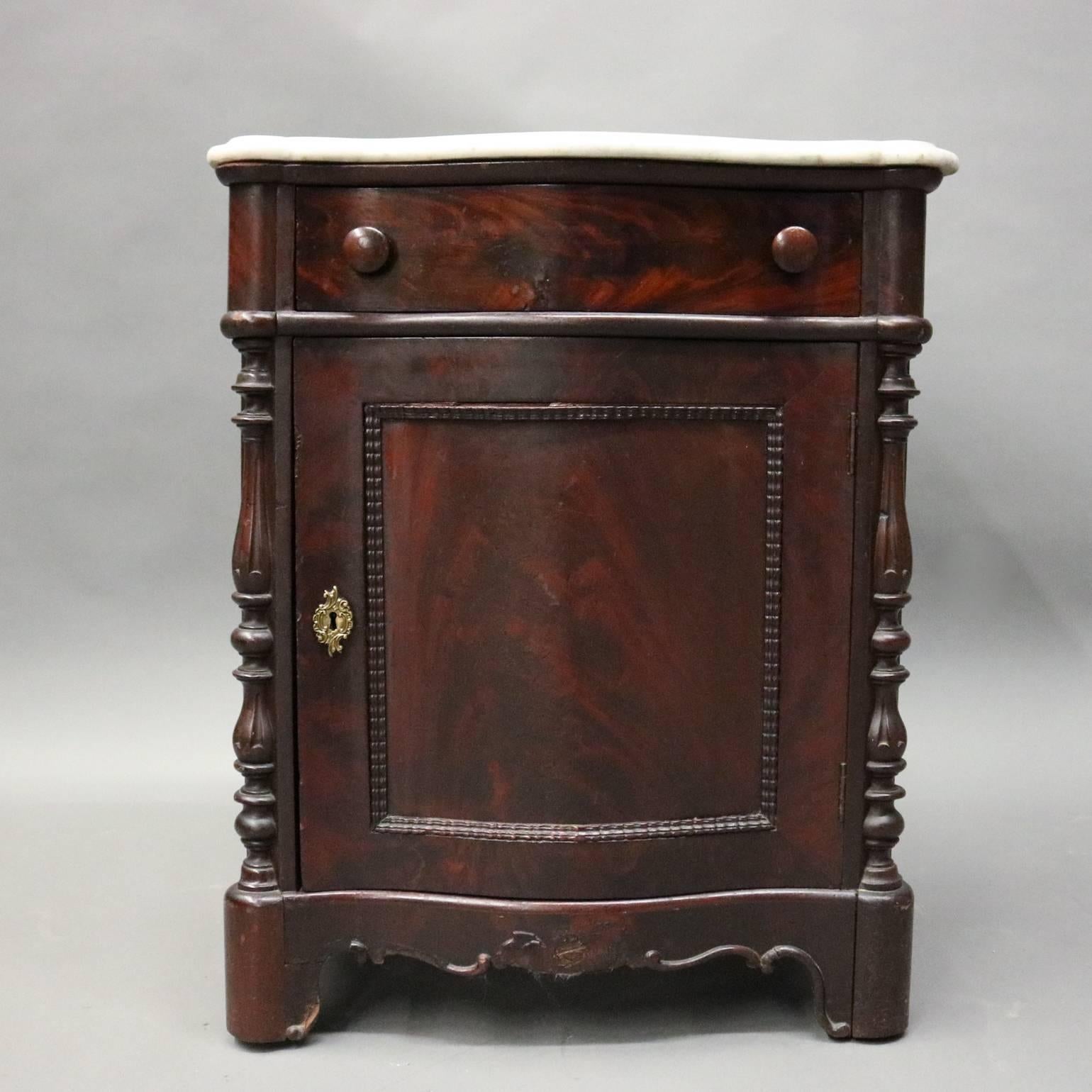 Antique commode features serpentine marble top mahogany case with single drawer above drawer with beaded reserve opening to shelved cabinet and flanked by half columns, circa 1880

Measures: 29" H x 24" W x 16.5" D.
