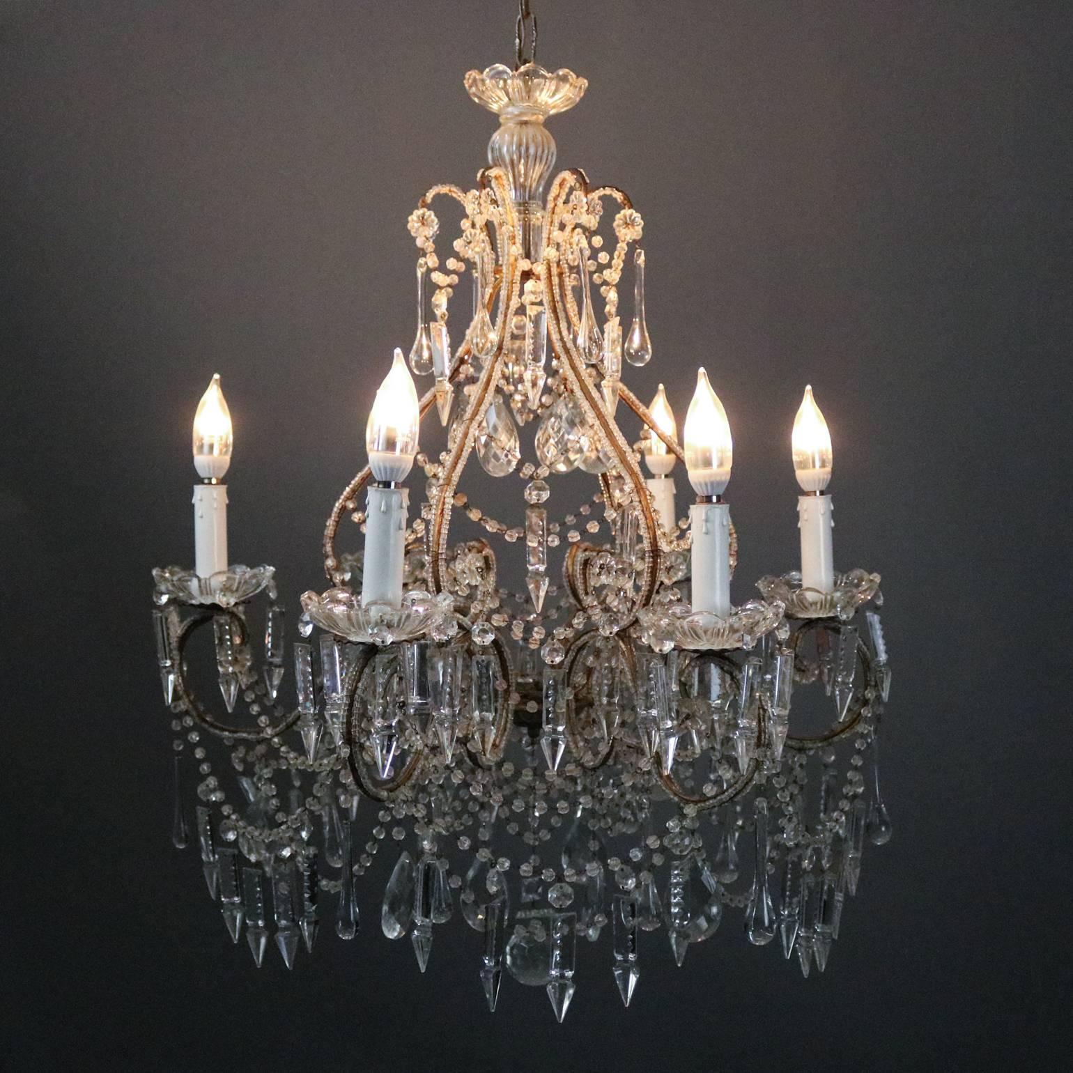 Antique French style six-light chandelier features curvilinear scrolled bronze frame decorated overall with strung and drop cut crystals, newly re-wired, circa 1930

Measures: 44