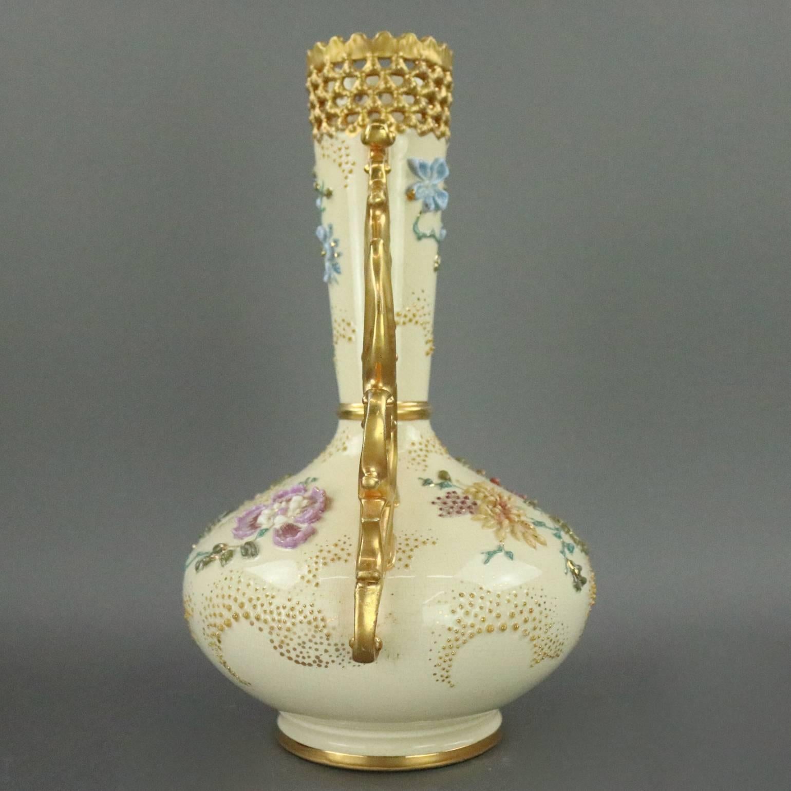 Antique Hungarian Fischer J. Budapest vase features hand-painted and applied floral and foliate decoration, reticulated scroll and foliate gilt double handles and collar, Fischer J. Budapest mark on base, circa 1900

Measures: 12