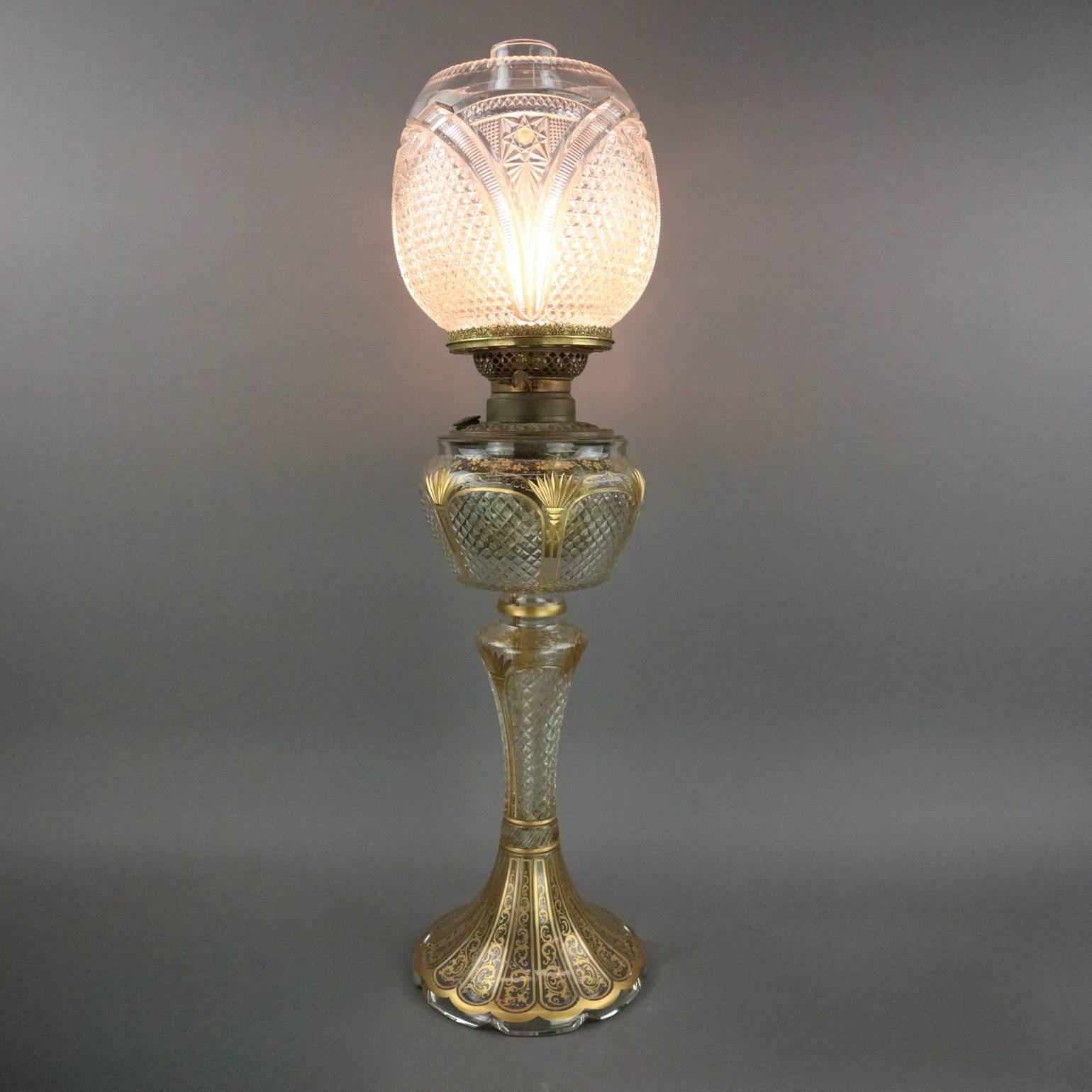 Antique Bradley & Hubbard banquet lamp features cut-glass base and shade decorated with gilt floral and scroll design, signed B&H, electrified, circa 1890.

Measures: 25" height x 7" diameter; 4" diameter fitter.