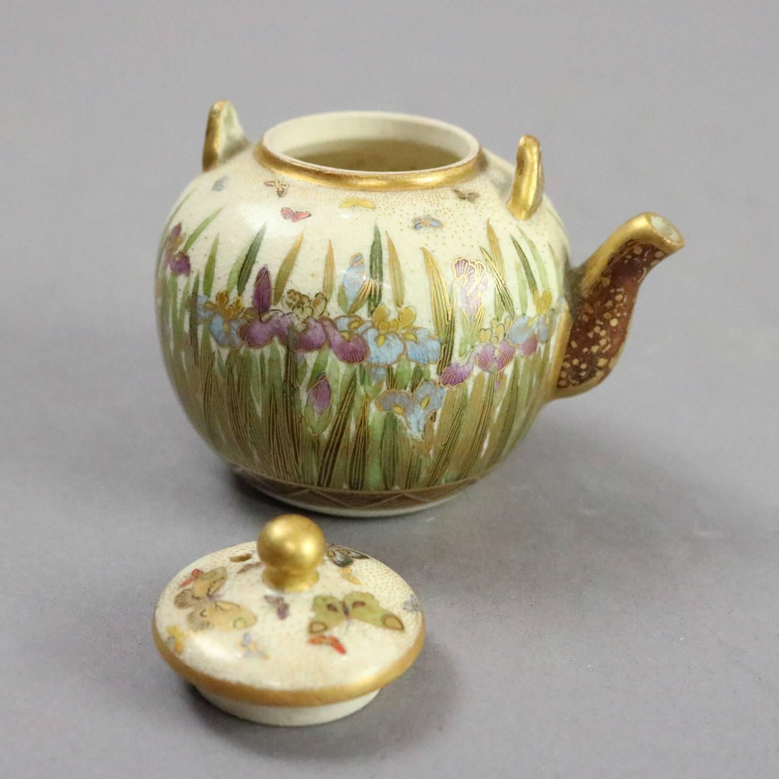 Miniature antique Art Nouveau Japanese Satsuma porcelain lidded tea pot features hand-painted and gilt floral decoration of Iris garden and butterflies, original label on base, circa 1920.

Measures: 2.5" H x 3" W x 2" D.