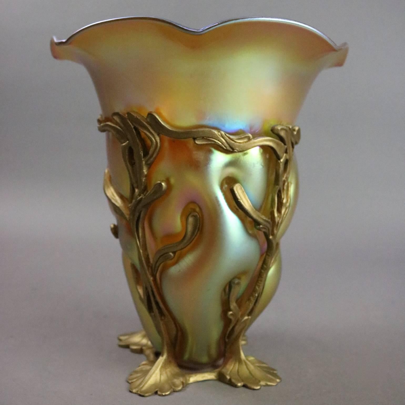 Antique Art Nouveau vase features Louis Comfort Tiffany Favrile art glass flared vase housed in foliate cast bronze footed frame, signed on vase base L.C. Tiffany Favrile, signed on bronze S&S ART. CA., circa 1920

Measures: 8.75