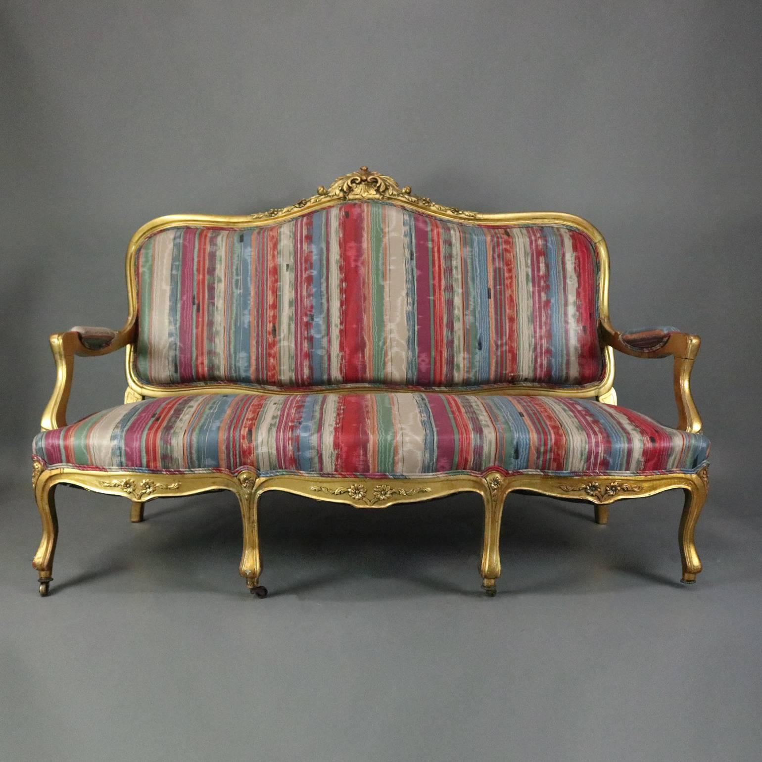 Antique French Louis XIV style upholstered settee feature carved giltwood construction with acanthus and foliate decoration, circa 1870

Matching pair of armchairs and side chairs listed separately

Measures - 43" H x 63" W x 25"