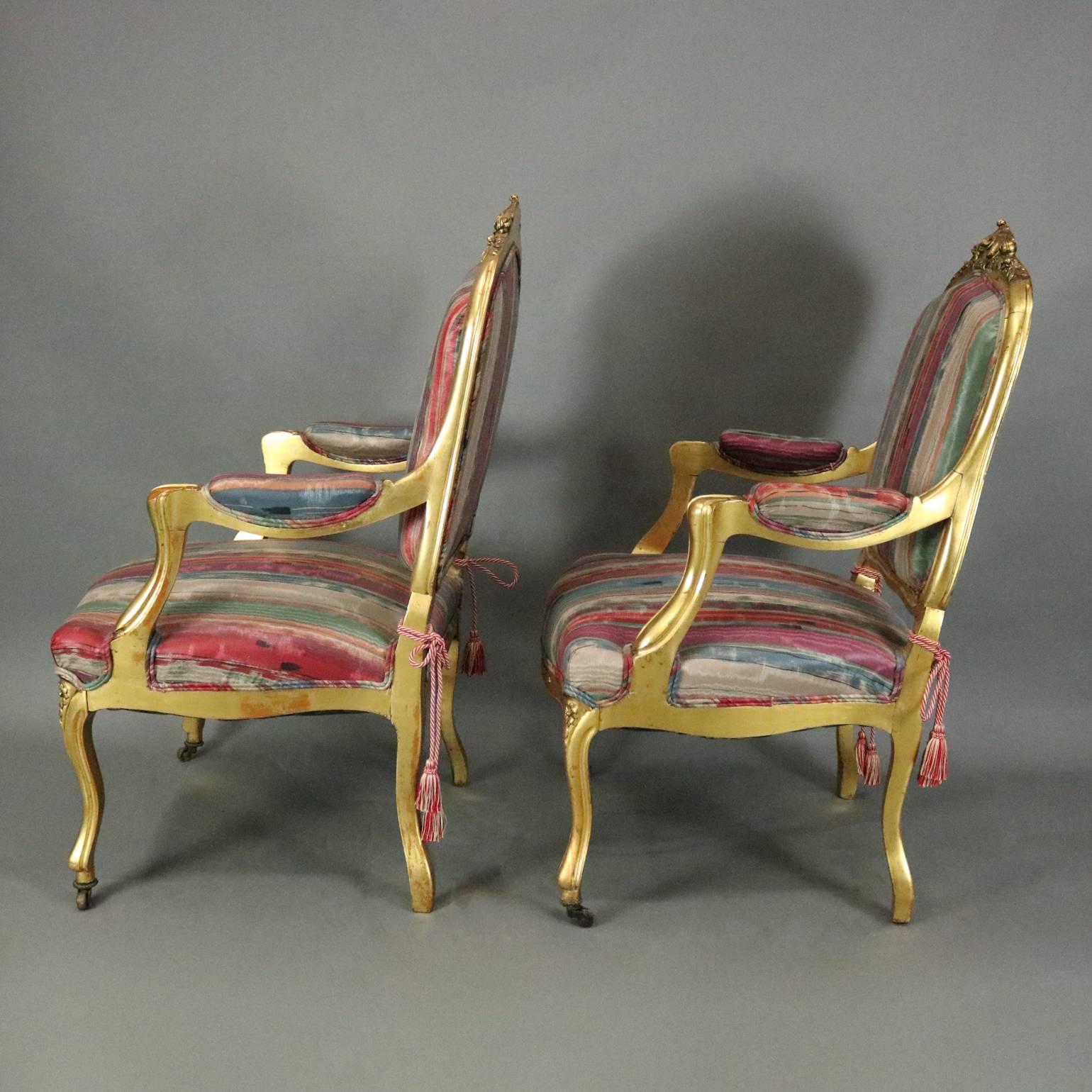 Pair of antique French Louis XIV style upholstered armchairs feature carved giltwood construction with acanthus and foliate decoration, circa 1870

Matching settee and side chairs listed separately

Measures: 40