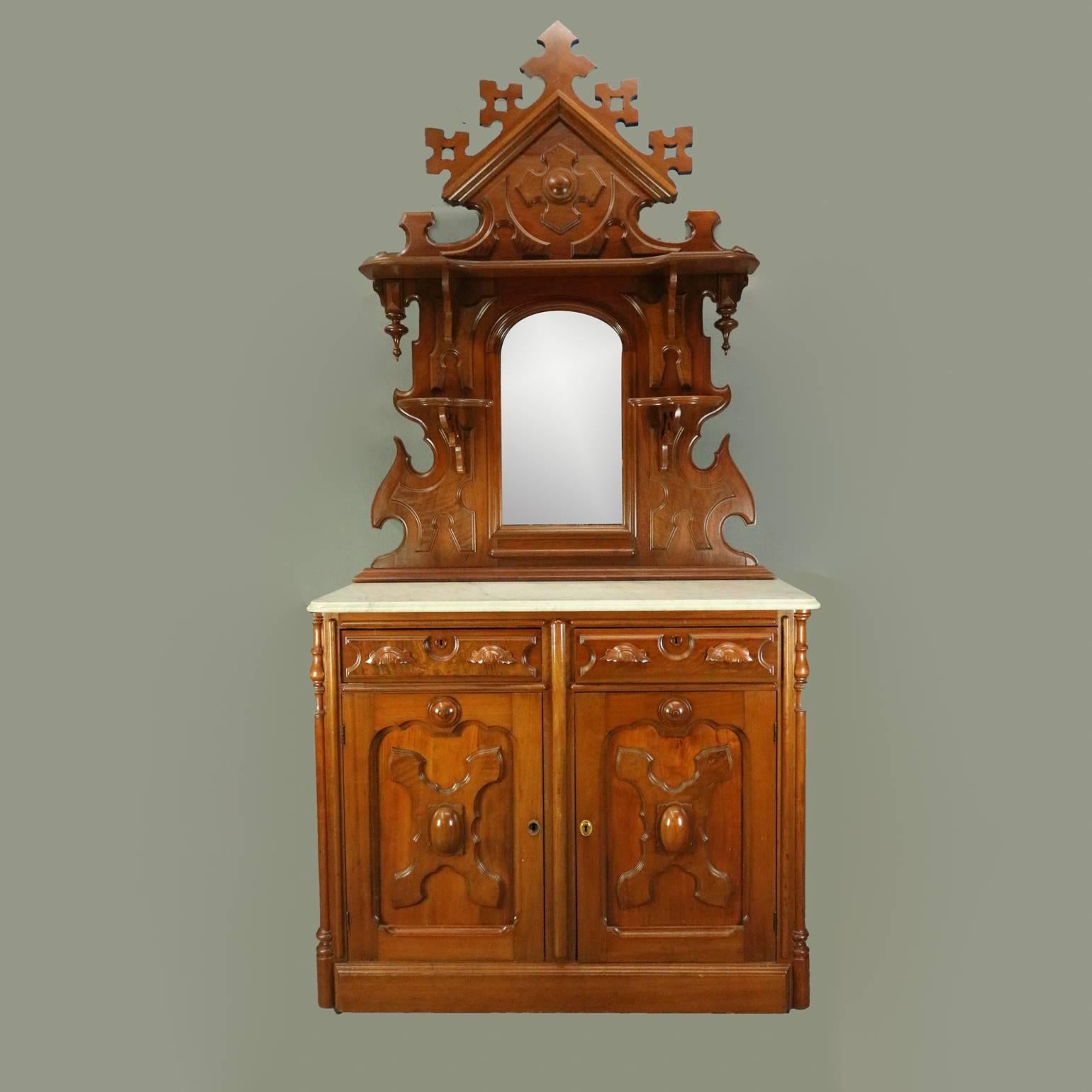 Antique heavily carved oak sideboard features two drawers above two doors with carved reserves, cabinet flanked by columns and topped with marble, mirror flanked by candle stands and topped with stylized floral crest, circa 1880

Measures: 99