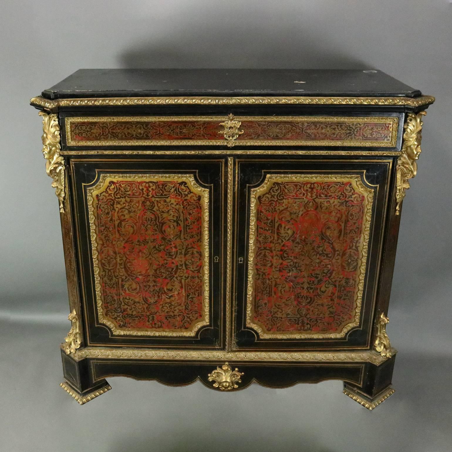 19th century antique French Boulle credenza cabinet features ebonized case, two doors with tortoise reserves framed in ormolu framed in gilt columns with upper ormolu mask and lower foliate ormolu, side reserves with central ormolu shield and