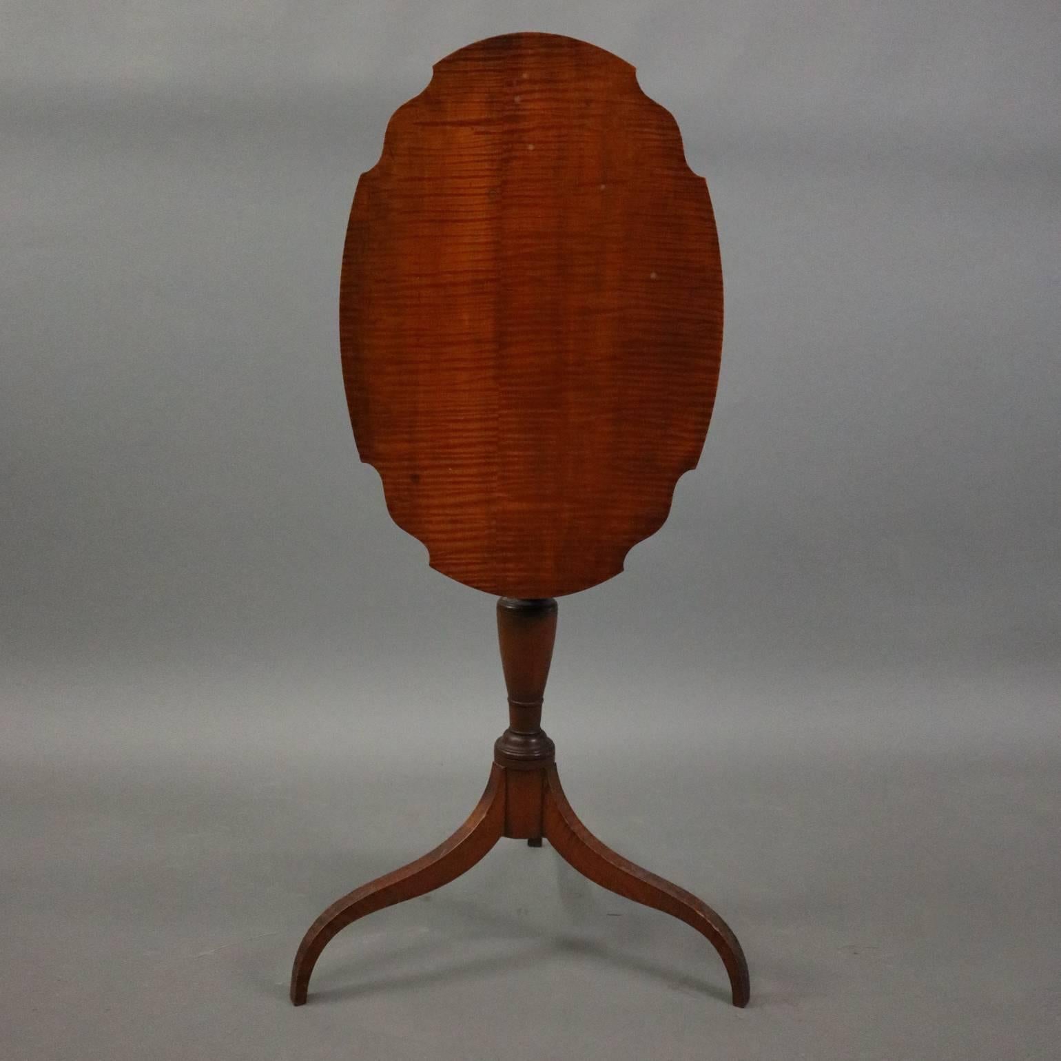 Antique Federal tiger maple lamp stand features scalloped tilt top and spider legs, circa 1850.

Measures 30" H x 24.5" W x 16.5" D (when tabletop is flat).