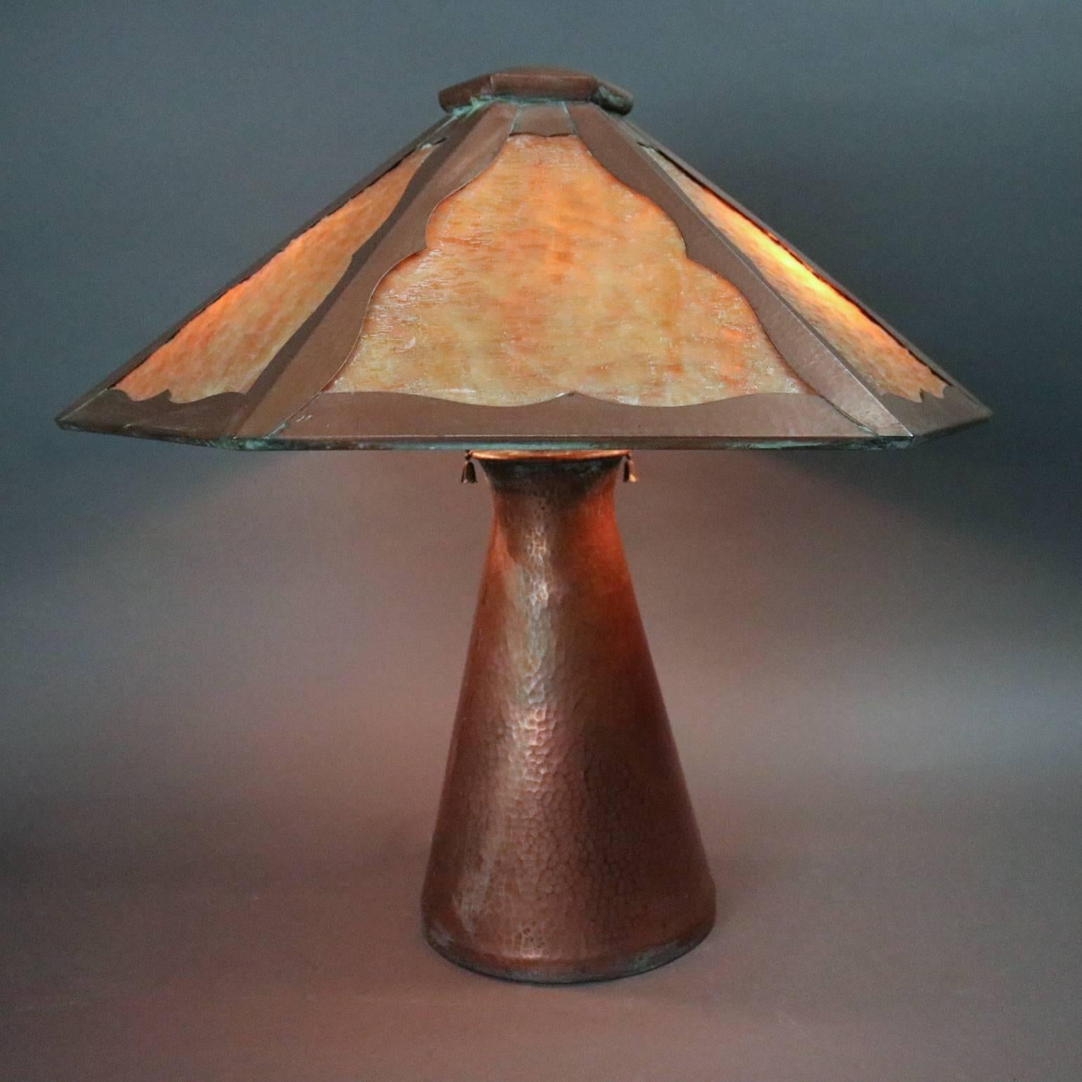 Antique Arts and Crafts Mission style table lamp features hammered copper conical base and paneled slag glass shade, circa 1910

Measures: 19