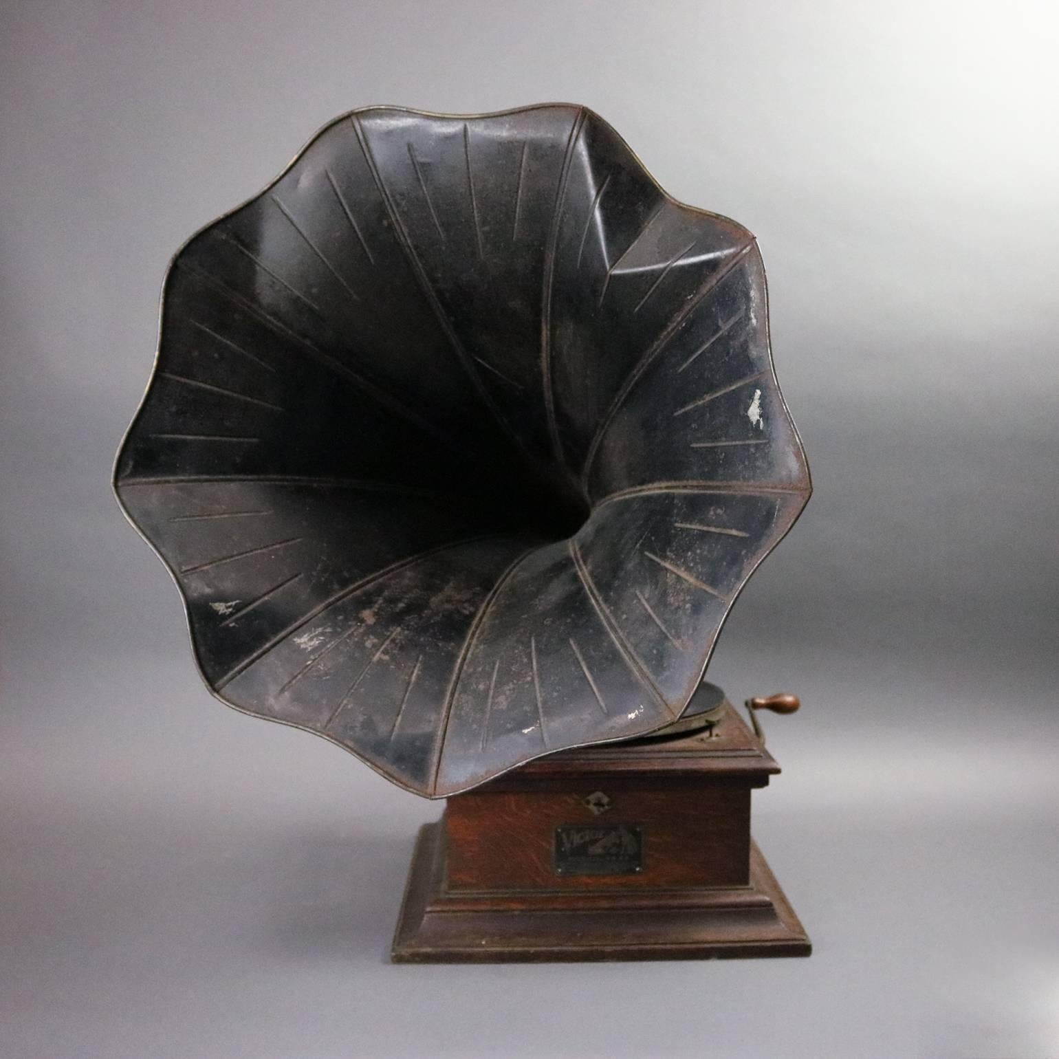 Antique Victor Victrola phonograph features oak case with gilt banded external tin horn, original label and plate, in working order, circa 1900

Measures: 27