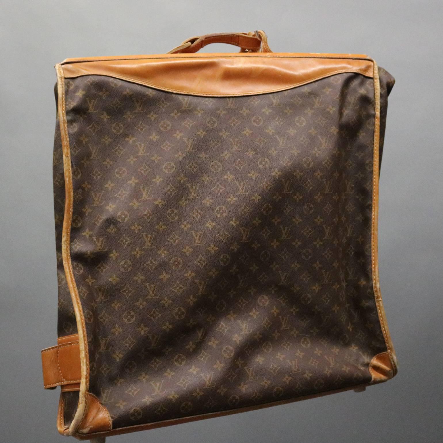 Vintage French Louis Vuitton style traveling bag features quality construction with main garment compartment and additional zippered storage pouches, reminiscent of the authentic Louis Vuitton monogram canvas portable Bandouliere garment bag, made