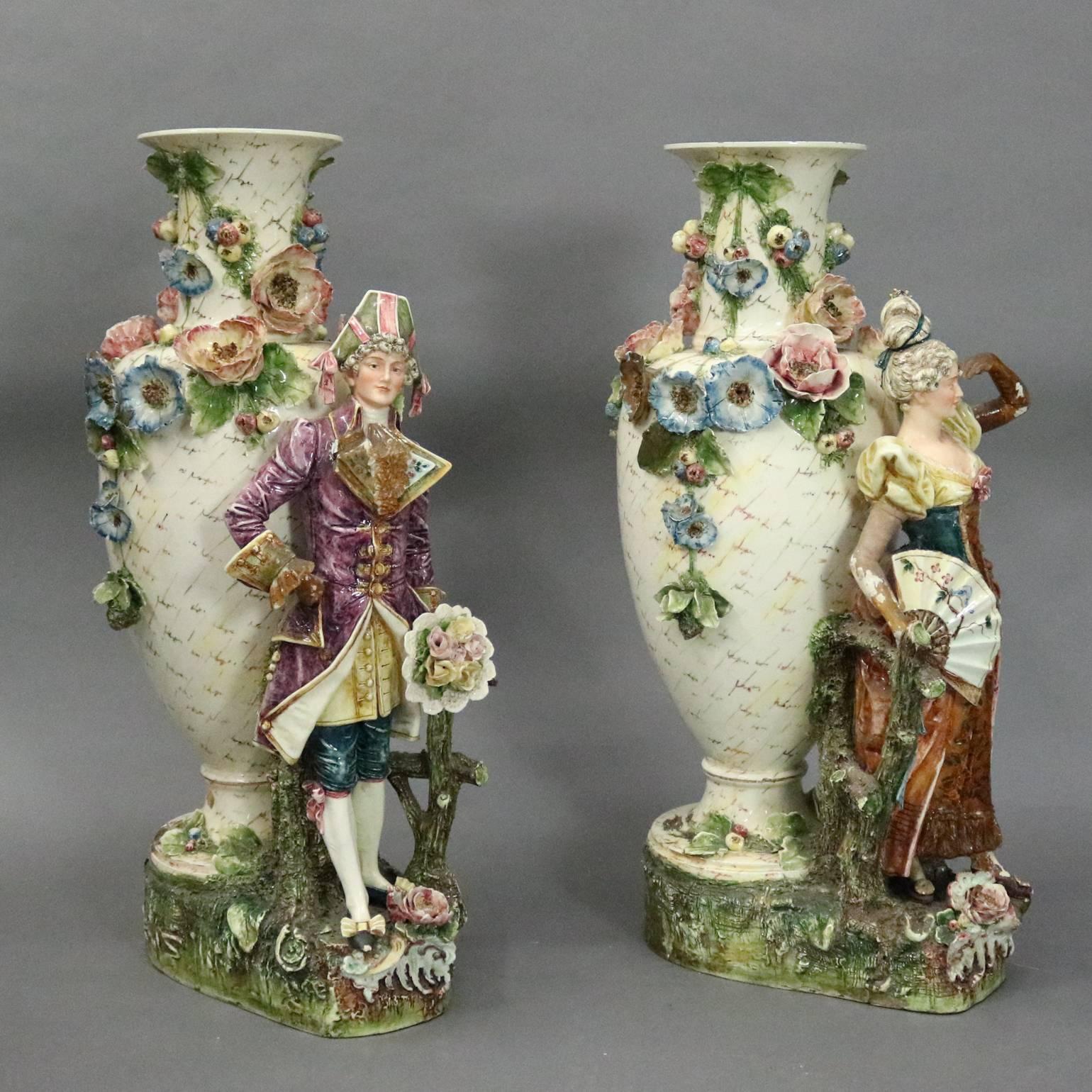 Pair of monumental antique Austrian German majolica figural floor vases feature lady and man in traditional period garb in countryside stetting, applied flowers, circa 1880

Measure: 33" H x 18" D; 4.5" diameter at mouth.