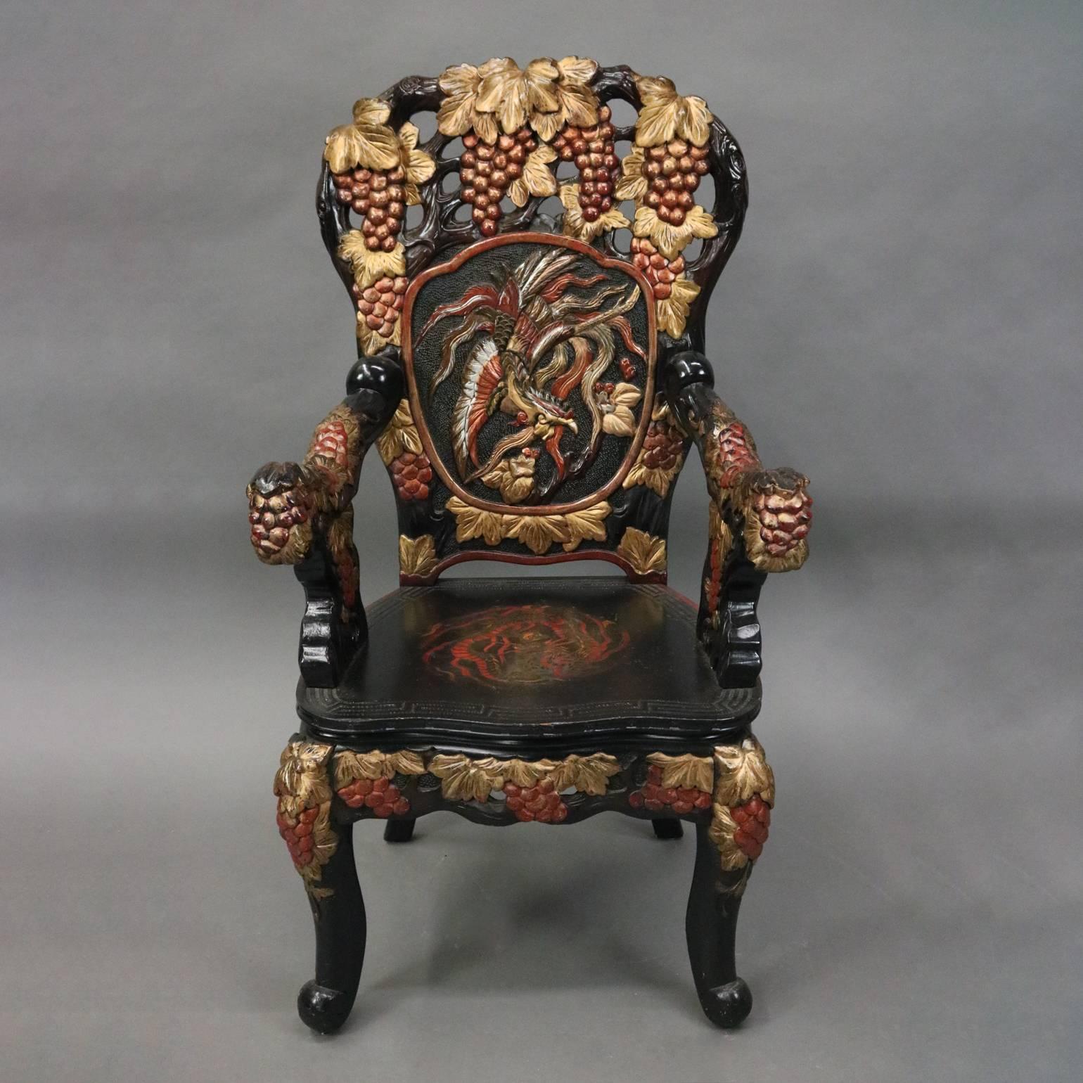 Vintage heavily carved hardwood ebonized and polychromed Chinese throne chair features pierced back with central medallion of phoenix surrounded by grape laden vines, seat with central dragon, en verso back with central medallion of feathers