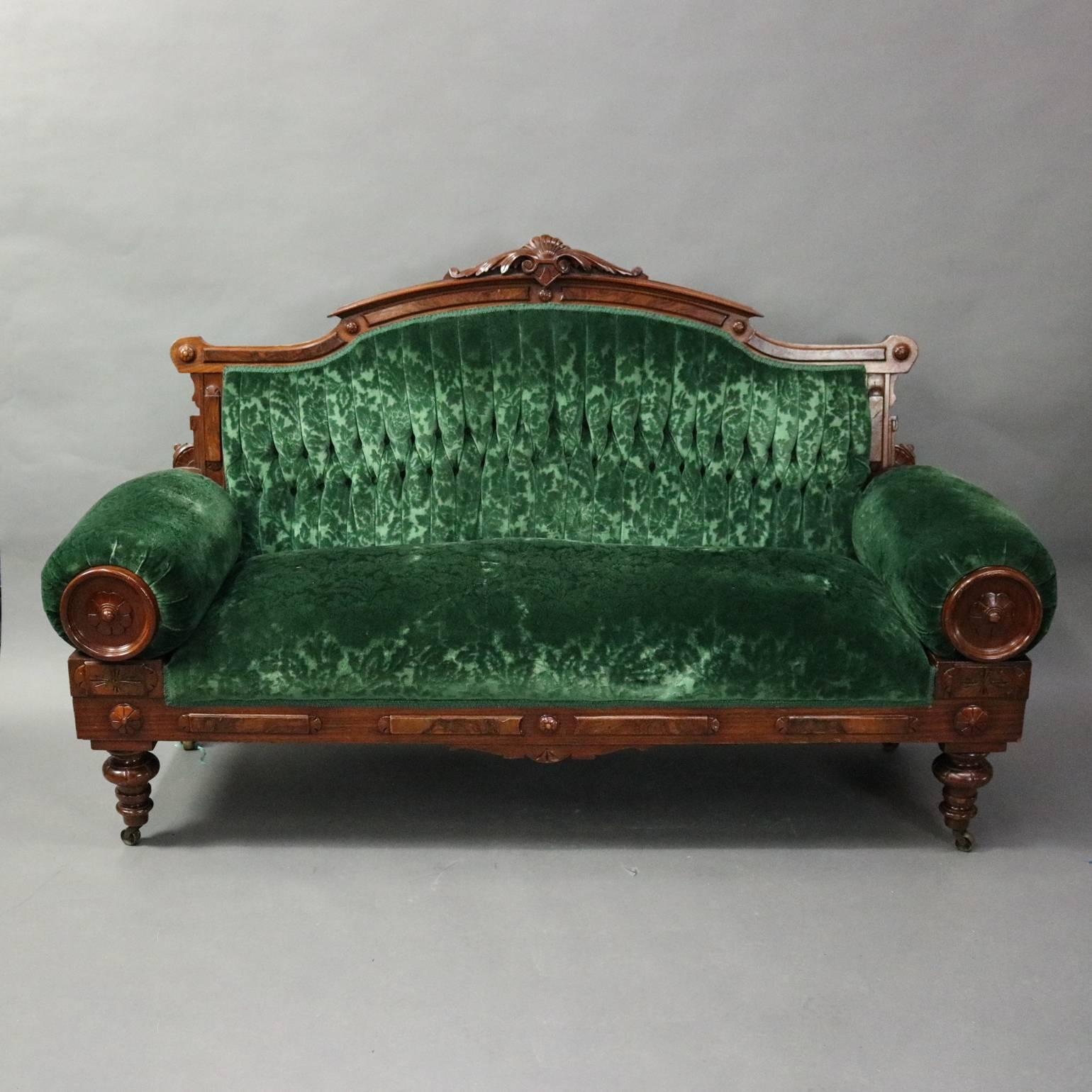 Antique Eastlake parlor set features walnut and burl frame with carved shell, acanthus, and rosettes, emerald green upholstery; includes settee, four side chairs, one armchair and footstool, circa 1880.

Measures: 43