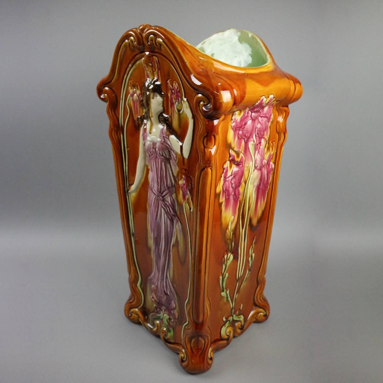 Antique Austrian Art Nouveau Majolica art pottery umbrella stand features full length high relief portrait of woman on front with lilies on each side, floral and foliate decorated, reminiscent of Louis Icart and Erte, circa 1920.

Measures: 26.5