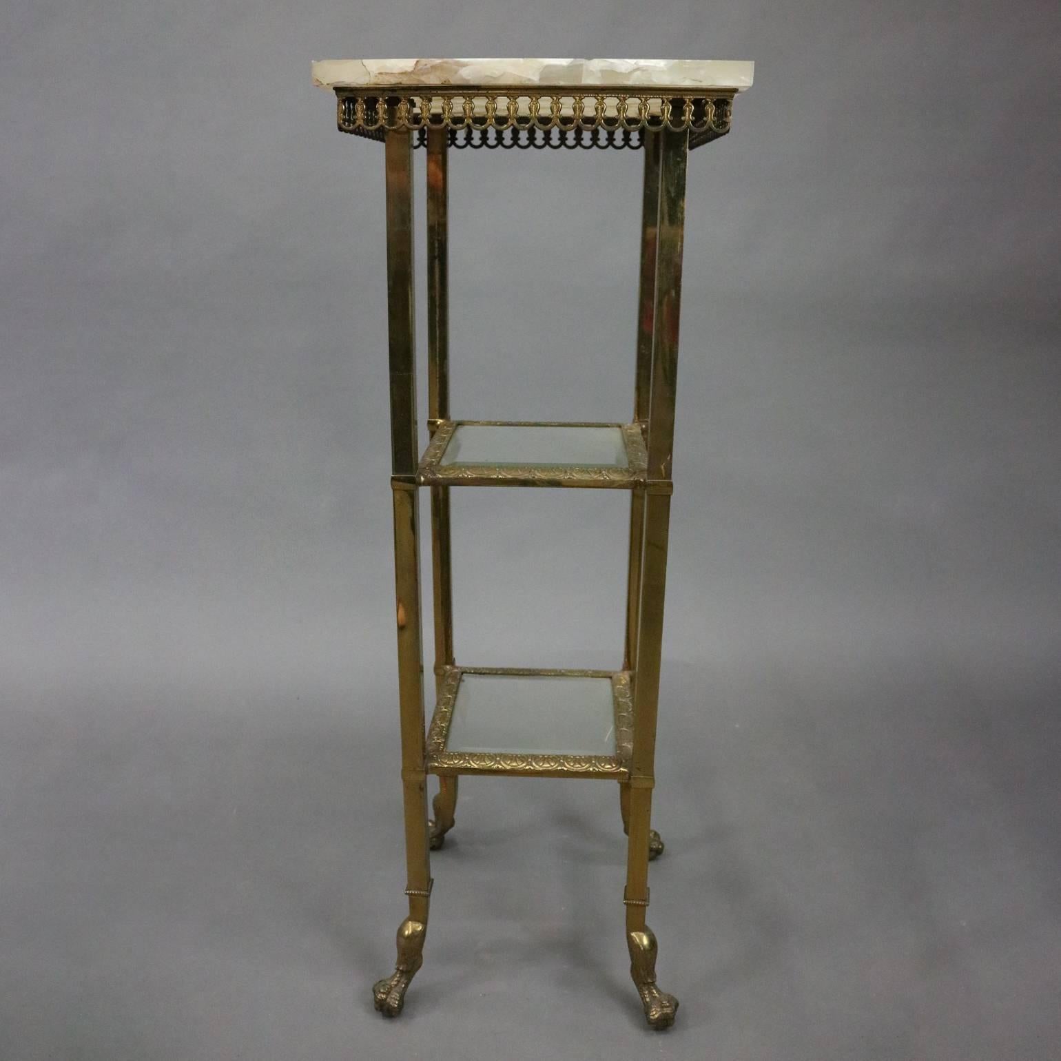 Antique French brass plant stand features onyx top atop pierced skirt and beveled glass shelves, seated on claw feet, circa 1880

Measures: 39.5" H x 14" W x 14" D.