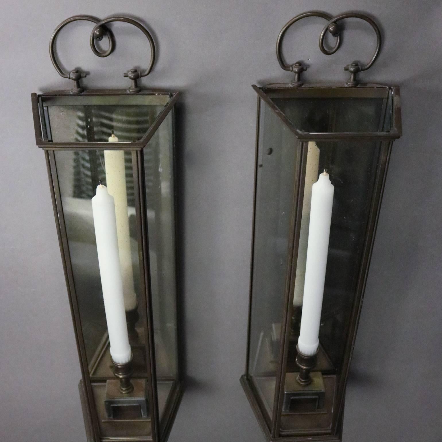 Pair of vintage Colonial Williamsburg bronze and glass cased mirror back candle wall sconces, 20th century

Measures: 20" H x 6" W x 5" D.