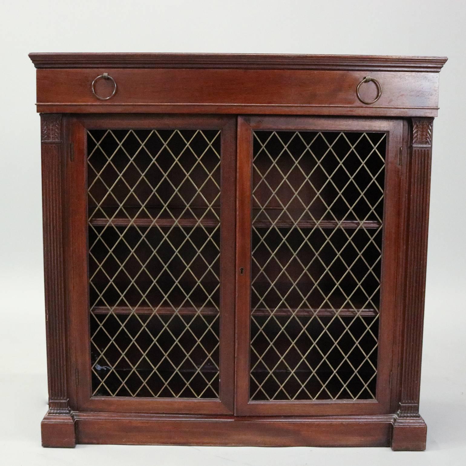 Vintage mahogany credenza by Charak Furniture Co., Boston, MA, features double metal mesh front doors flanked by reeded columns with carved acanthus capitals, shelved interior compartment and upper drawer, original label in drawer, circa