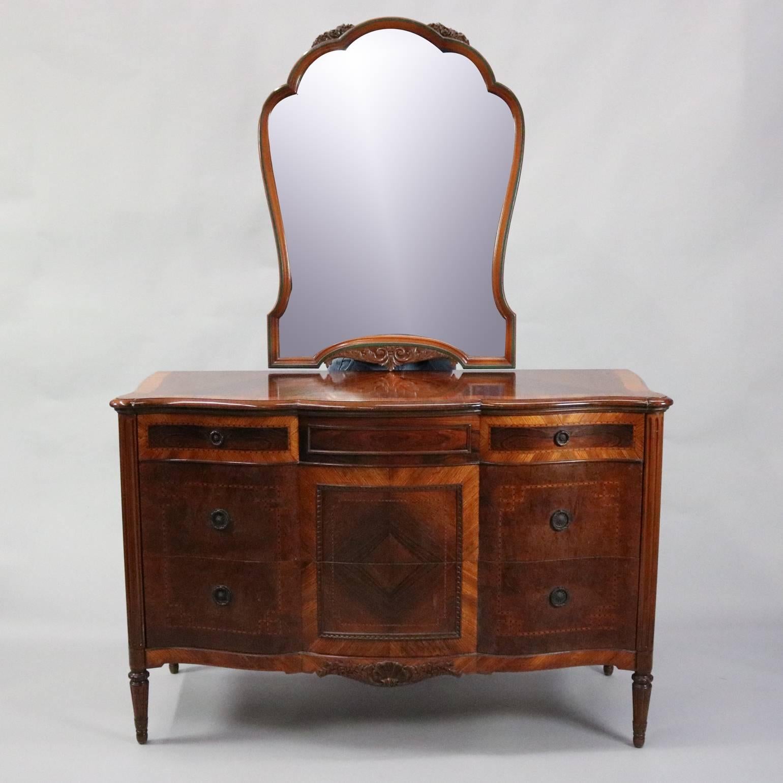 Antique mirrored low chest features bookmatched flame mahogany and burl panels with deeply striated and inlaid parquetry bordering, carved foliate and floral accents, bronze hardware, circa 1920

*Matching high chest and vanity listed