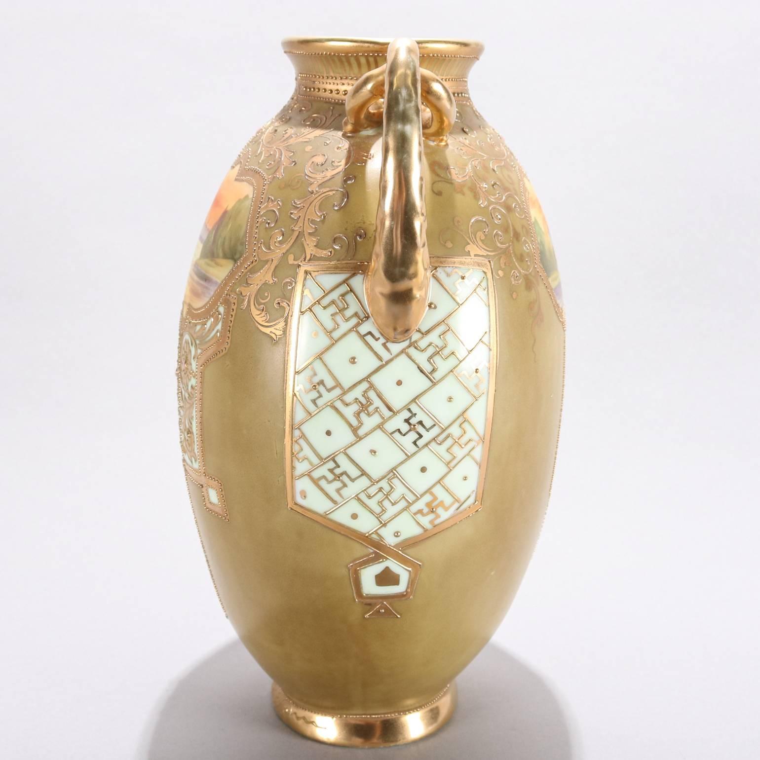 Large antique Nippon School porcelain urn form vase features finely detailed hand-painted reserves of lake/river landscape scenes, gilt foliate and moriage decoration throughout, rope form gilt applied handles, 19th century

Measures: 11" H x