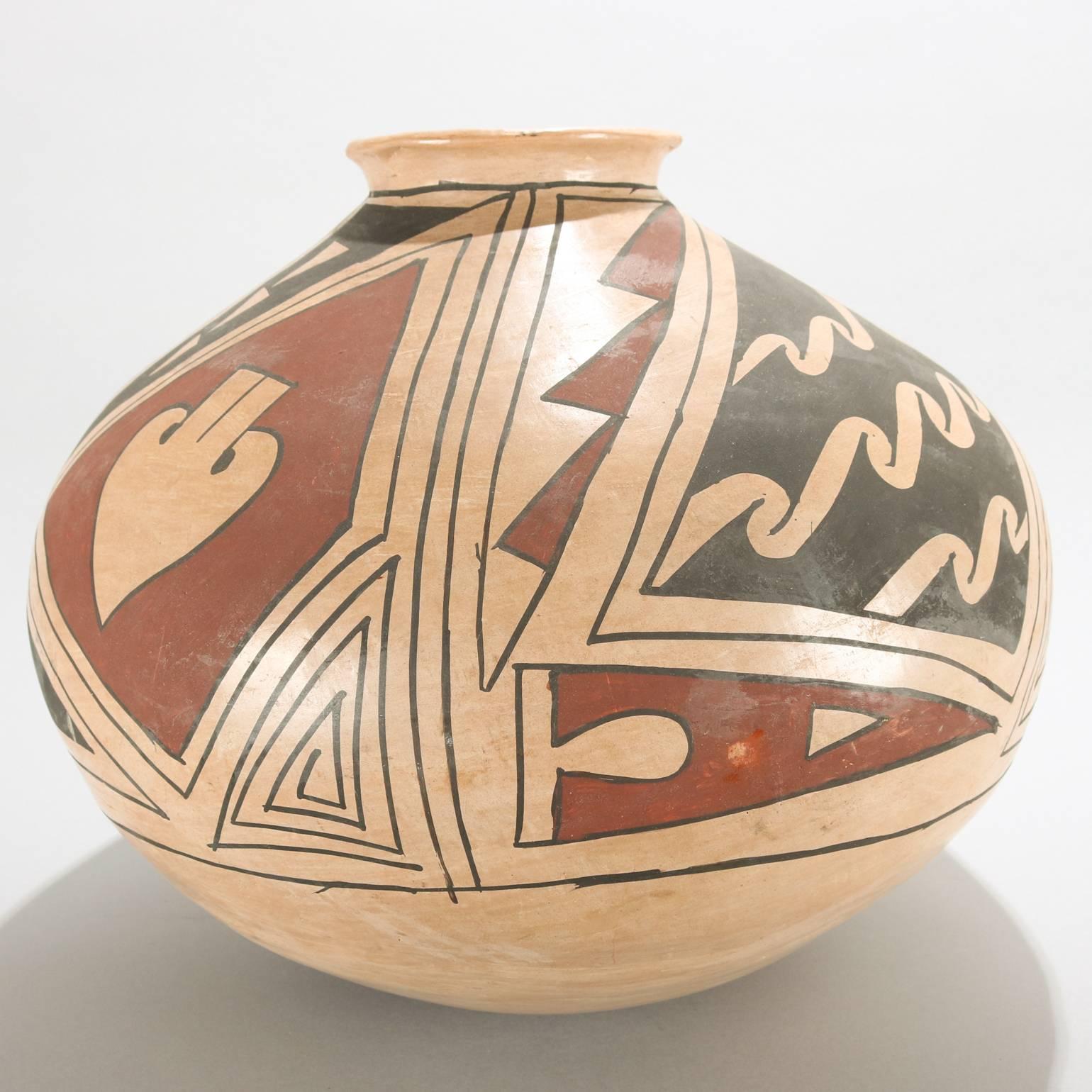 Oversized large antique Native American Indian Acoma Pueblo hand-painted thrown pottery water jar features stylized floral and geometric slip decoration, 20th century

Measures: 13" height x 13" diameter.

