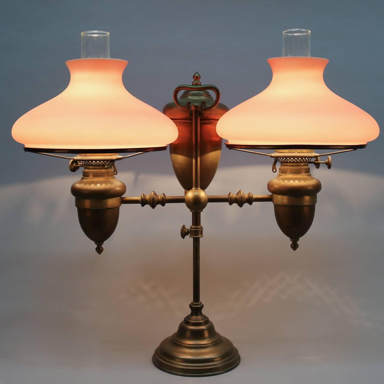 19th century electrified English brass adjustable double student lamp features Duplex burners and satin glass shades.

Measures: 25" H x 26" W x 10" D (10" fitter).