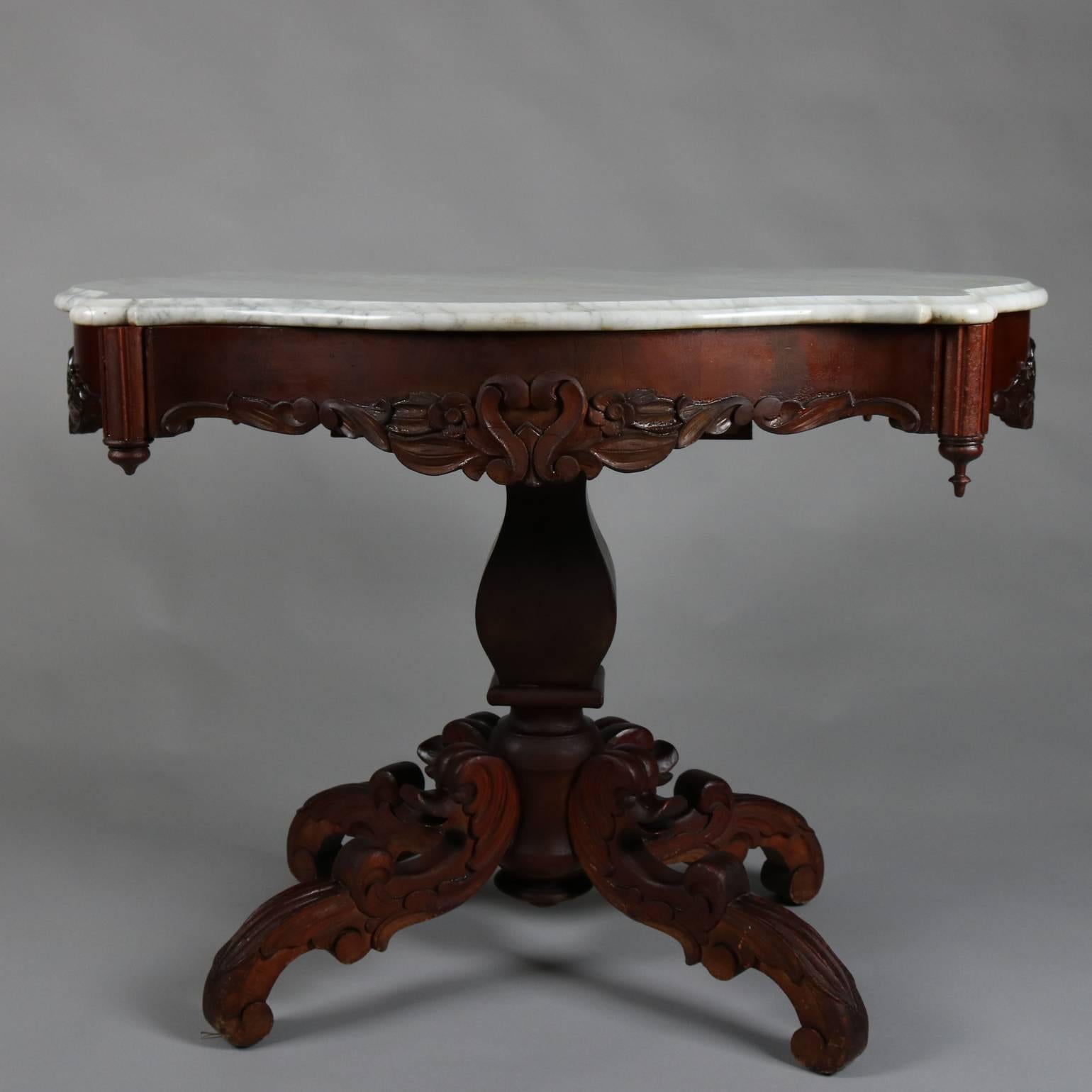 Antique mahogany side table features foliate carved apron with heart form opposing S-scroll decoration and corner drop finials supported on acanthus and dolphin legs and beneath marble turtle top, circa 1880

Measures - 28