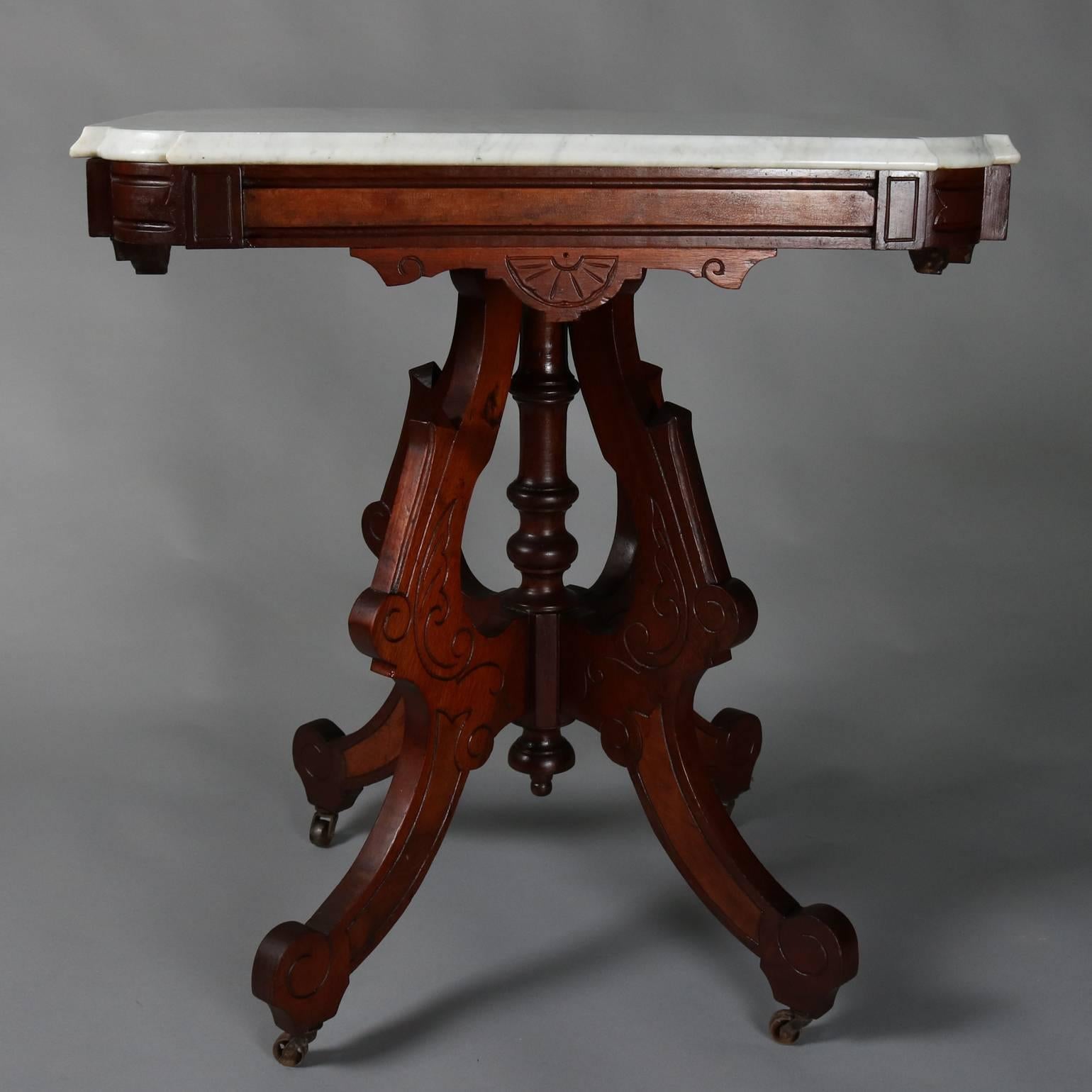 Antique Eastlake walnut side table features incised scroll and foliate decorated legs with central turned plinth supporting beveled marble top, circa 1880

Measures: 30" H x 29" W x 21" D.