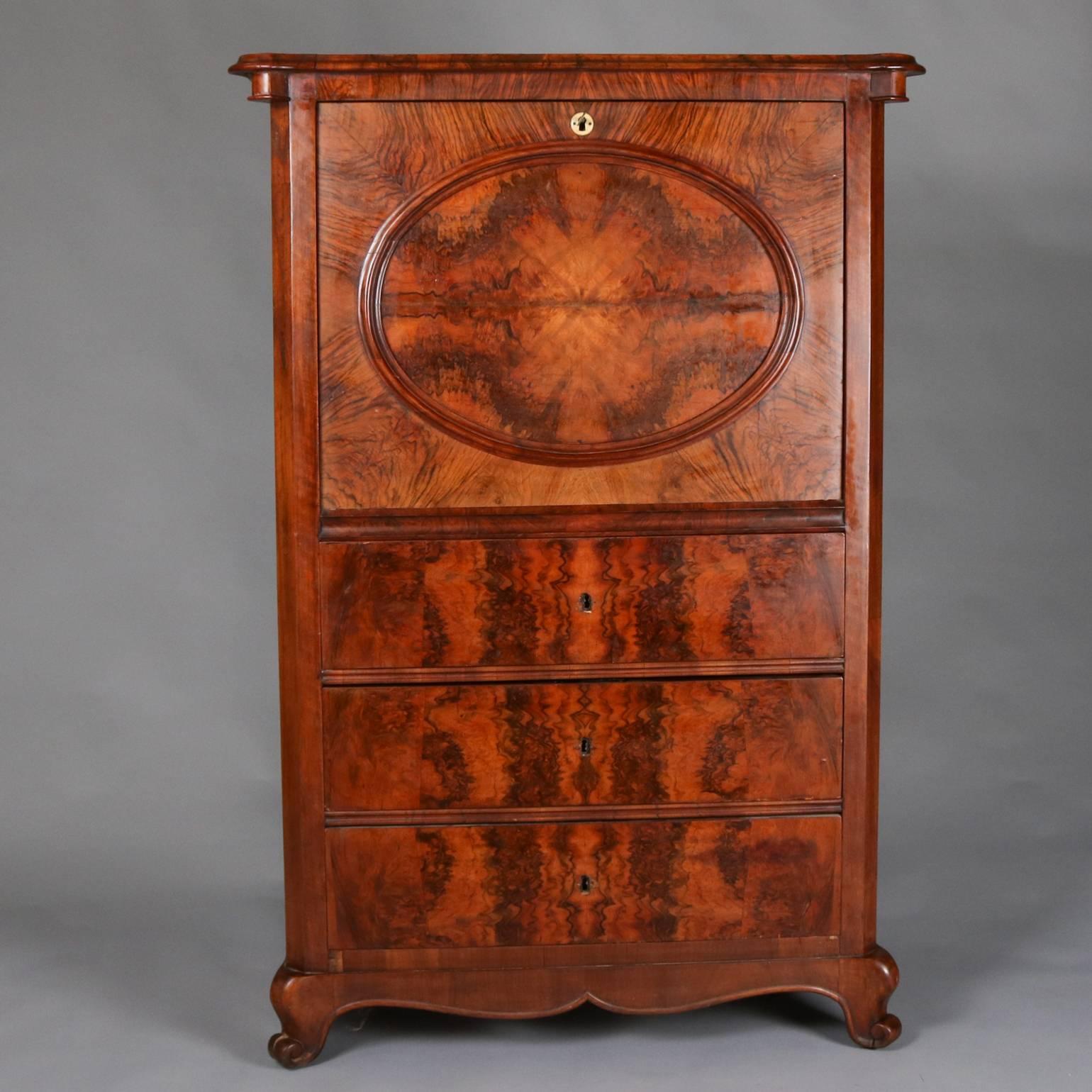 Antique Biedermeier burl walnut secretaire a' abattant (fall front secretary) features bookmatched central reserve with drop front opening to reveal writing surface and interior storage compartments above three long drawers and seated on scroll