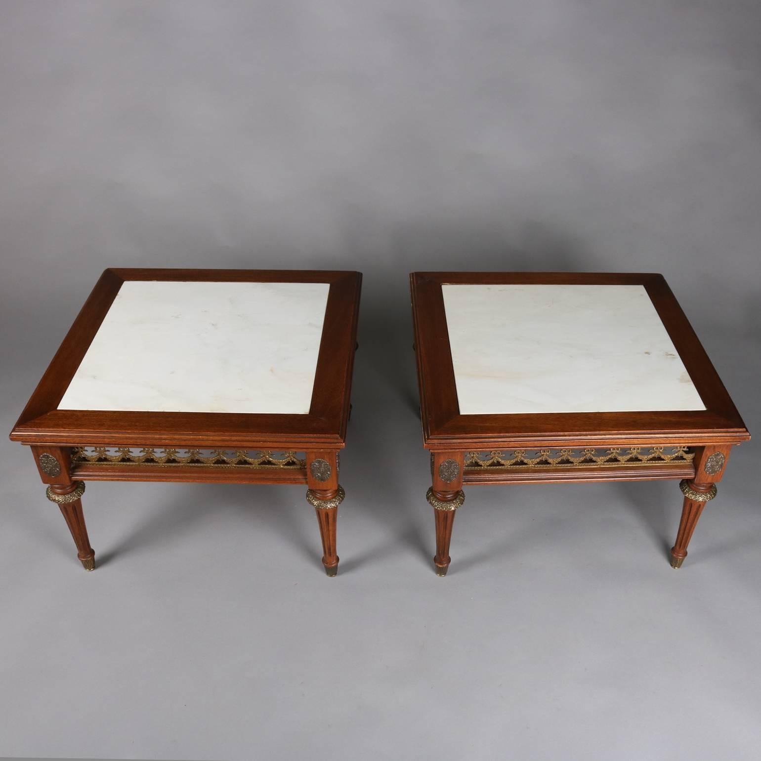 Pair of antique French Louis XVI style low table feature mahogany construction with cast garland form pierced apron, foliate cast bronze accoutrements, and inset marble tops, 19th century

Matching pair of end stands listed separately

Measure -