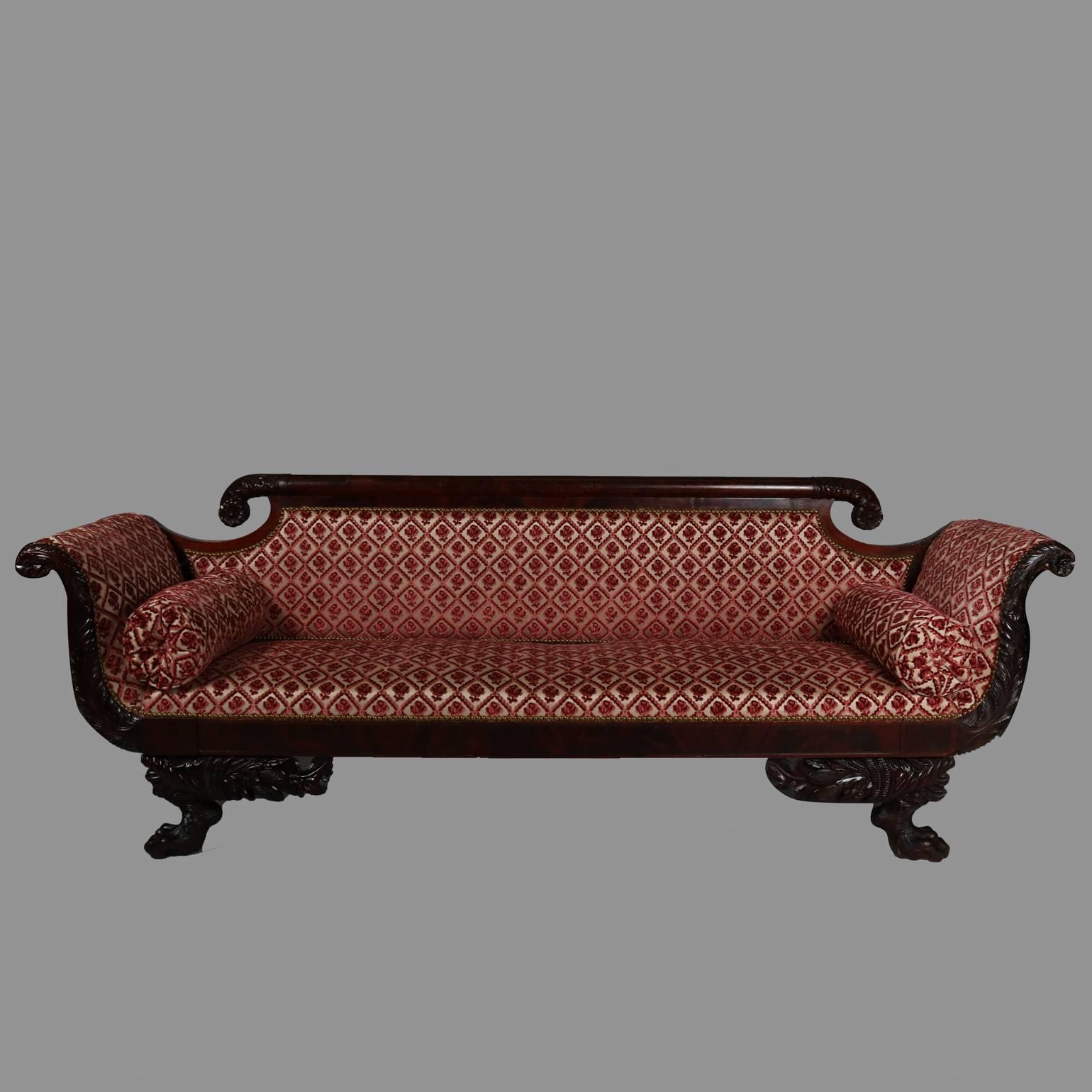 Antique American Empire Classical flame mahogany sofa features carved
acanthus scrolled arms and back, cornucopia and hairy lion paw feet with detailed knees, floral diaper pattern upholstery, 19th century.

Measures - 33