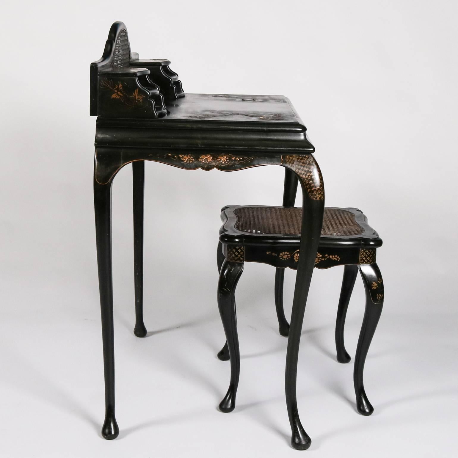 19th century English Japanned black lacquer writing desk and stool feature hand-painted village, landscape and floral decoration, caned stool seat and backsplash with flanking storage compartments, single central drawer, 19th century

Measures: