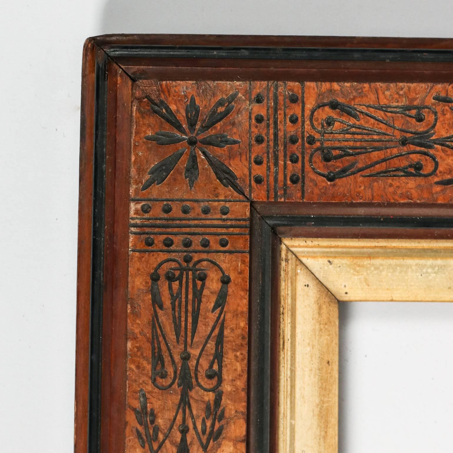 Antique aesthetic Eastlake mission walnut frame features ebonized floral and foliate decoration with internal gilt border, 20th century

Measures: 36" x 25.25" x 1.75" D, outer; 28.75" x 18", sight.