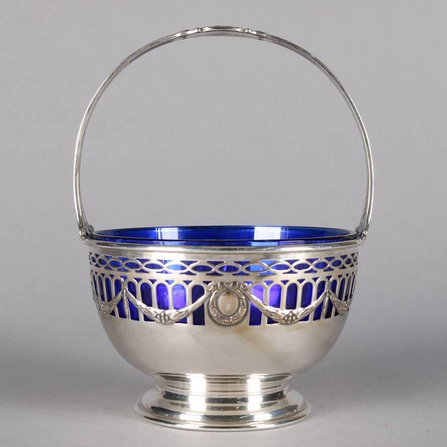 Antique Gorham pedestal basket features pierced sterling silver construction with swag decoration and cobalt blue glass basket, Gorham Sterling mark on base, 19th century


Measures: 6