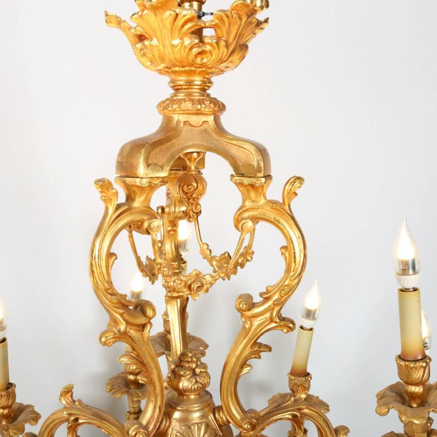 Antique Louis XIV gilt bronze chandelier features highly ornate and distinctly French scroll, acanthus and foliate form with fifteen arms terminating in candle lights, early 20th century.

Measures: 43