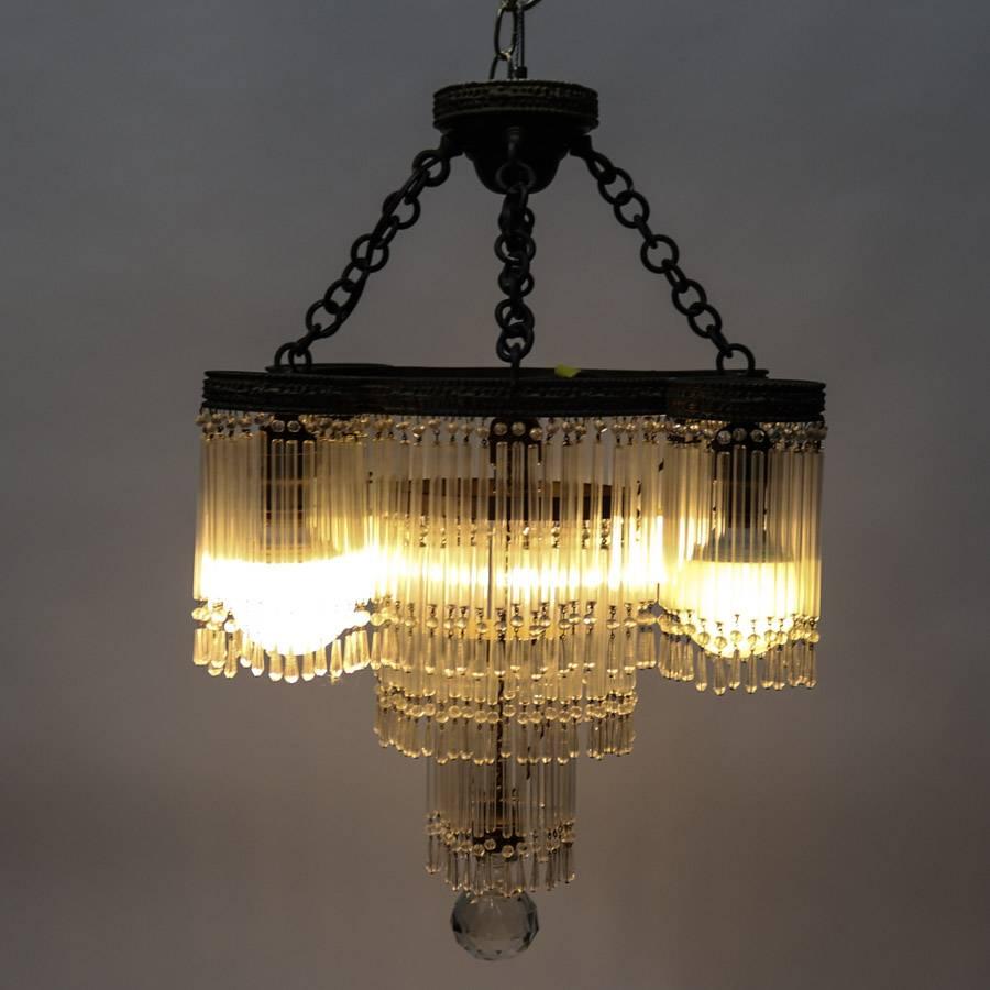 Antique Art Deco chandelier features tiered form with bronze frame, hanging crystal beaded skirting, and five lights, newly re-wired, circa 1920

Measures: 27" drop x 20" diameter.