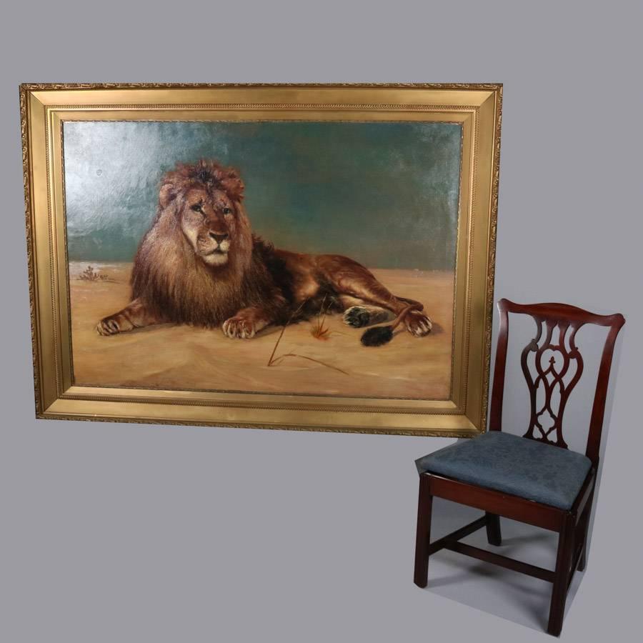 Monumental oil on canvas painting depicts recumbent lion in African dessert setting, housed in giltwood frame, 20th century

Measures: 54