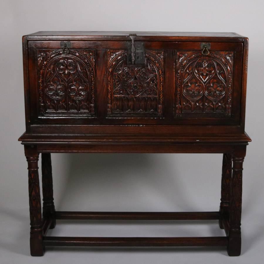 Antique Spanish Vargueno carved oak drop front desk features carved foilate reserves on drop front which opens to writing surface and internal storage compartments, 19th century

Measures: 47" H x 47" W x 17.5" D, closed.