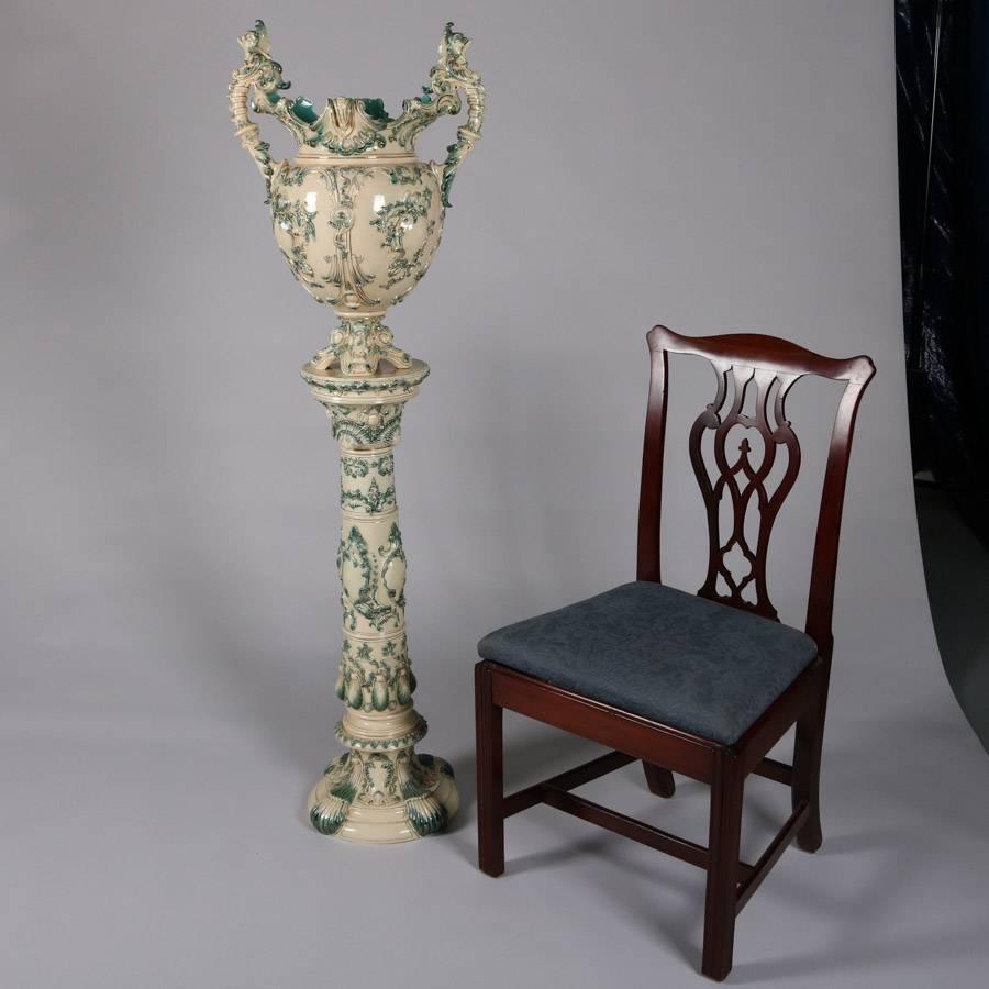 Oversized Majolica pottery jardinière and pedestal features double handle urn form and scroll, foliate and shell decoration with gilt highlights, marked "Made in Austria B", 19th century

Measures: 61" height x 18" diameter