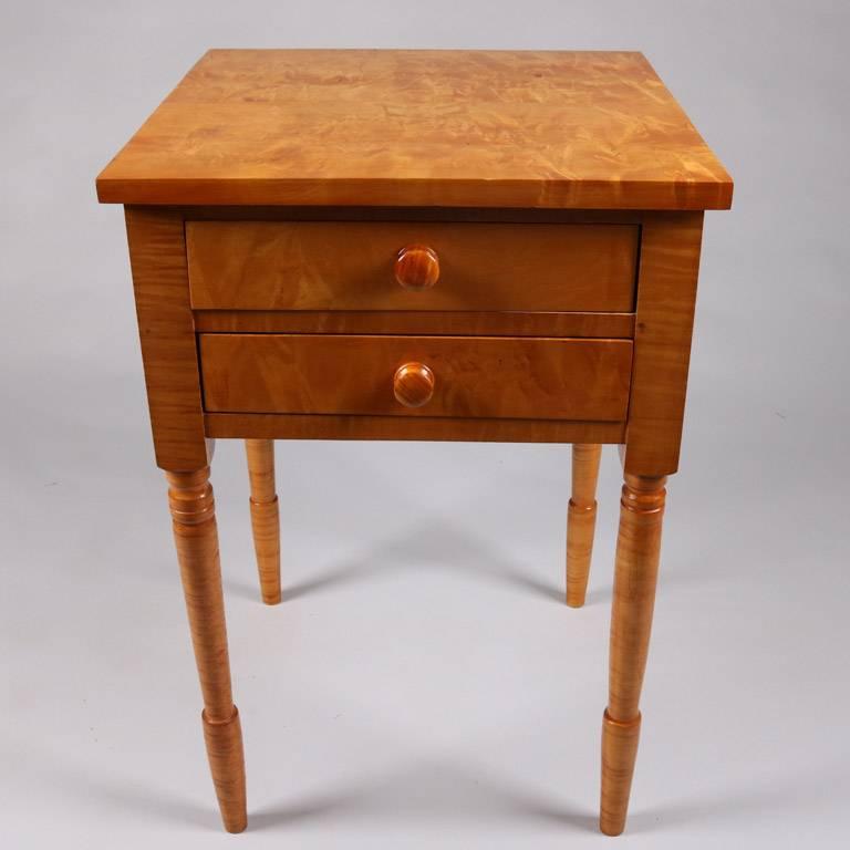 Sheraton style tiger maple stand features two drawers and is seated on turned legs, 20th century

Measures - 27" H x 18.25" W x 18" D.