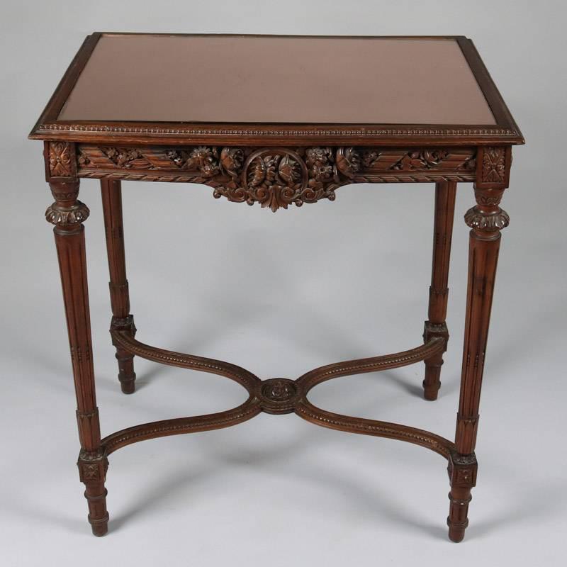 Antique French Louis XVI style side table features deeply carved floral and beaded decoration and copper mirror inset top, 19th century

Measures: 30" H x 27.5" W x 19.5" D.