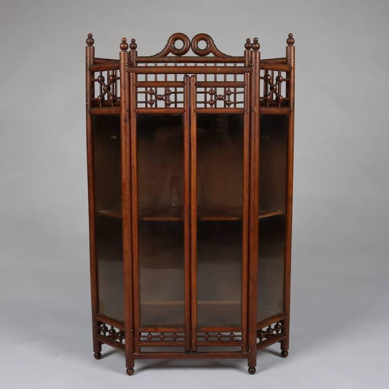 Antique Aesthetic Movement petite curio cabinet features bamboo construction with stick and ball gallery and apron, glass sides and doors and interior shelving, 19th century. Cabinet could be easily converted to a wall curio.

Measures: 35.5"